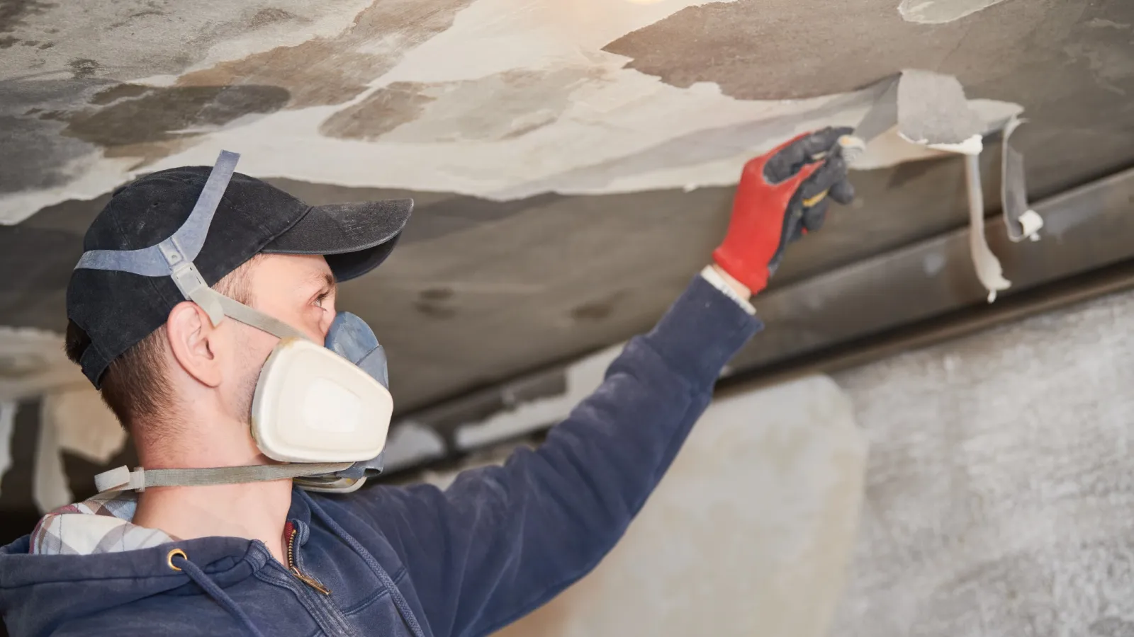 a man wearing a hat and goggles looking at a pipe