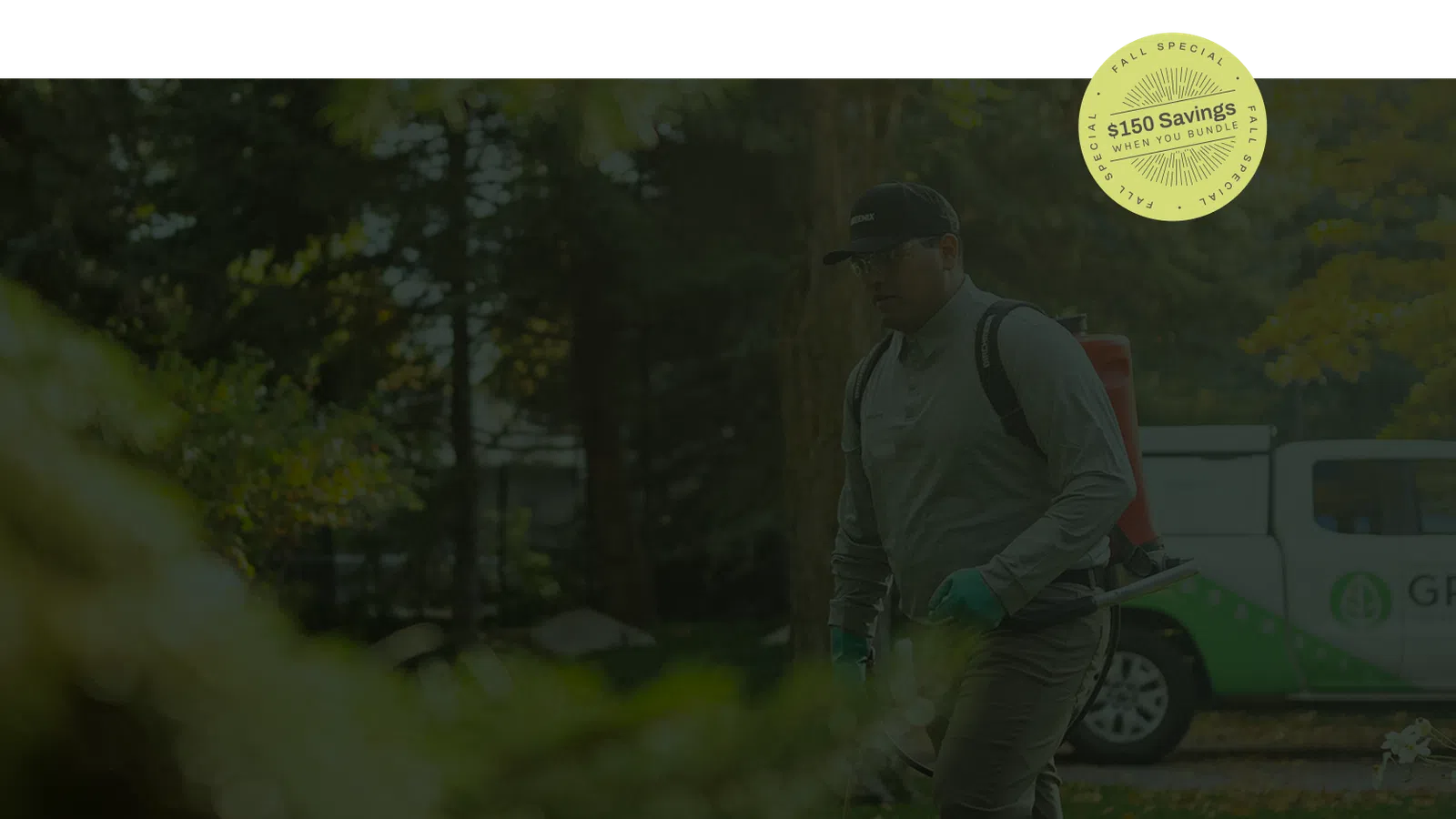 Man using backpack sprayer for lawn care in green outdoor setting with service truck in background