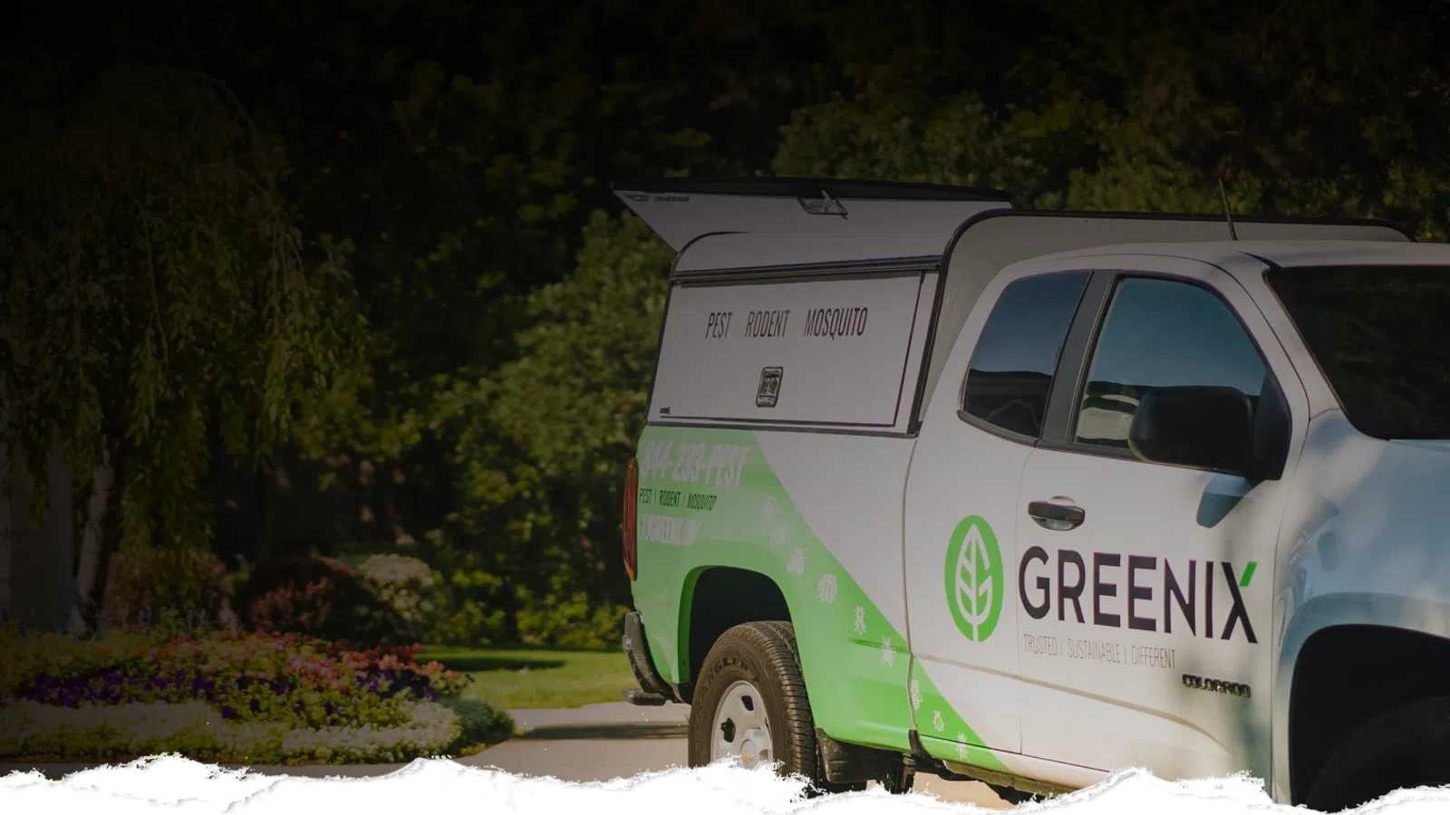 Greenix pest control truck parked with branding for pest, rodent, and mosquito services in a suburban neighborhood.