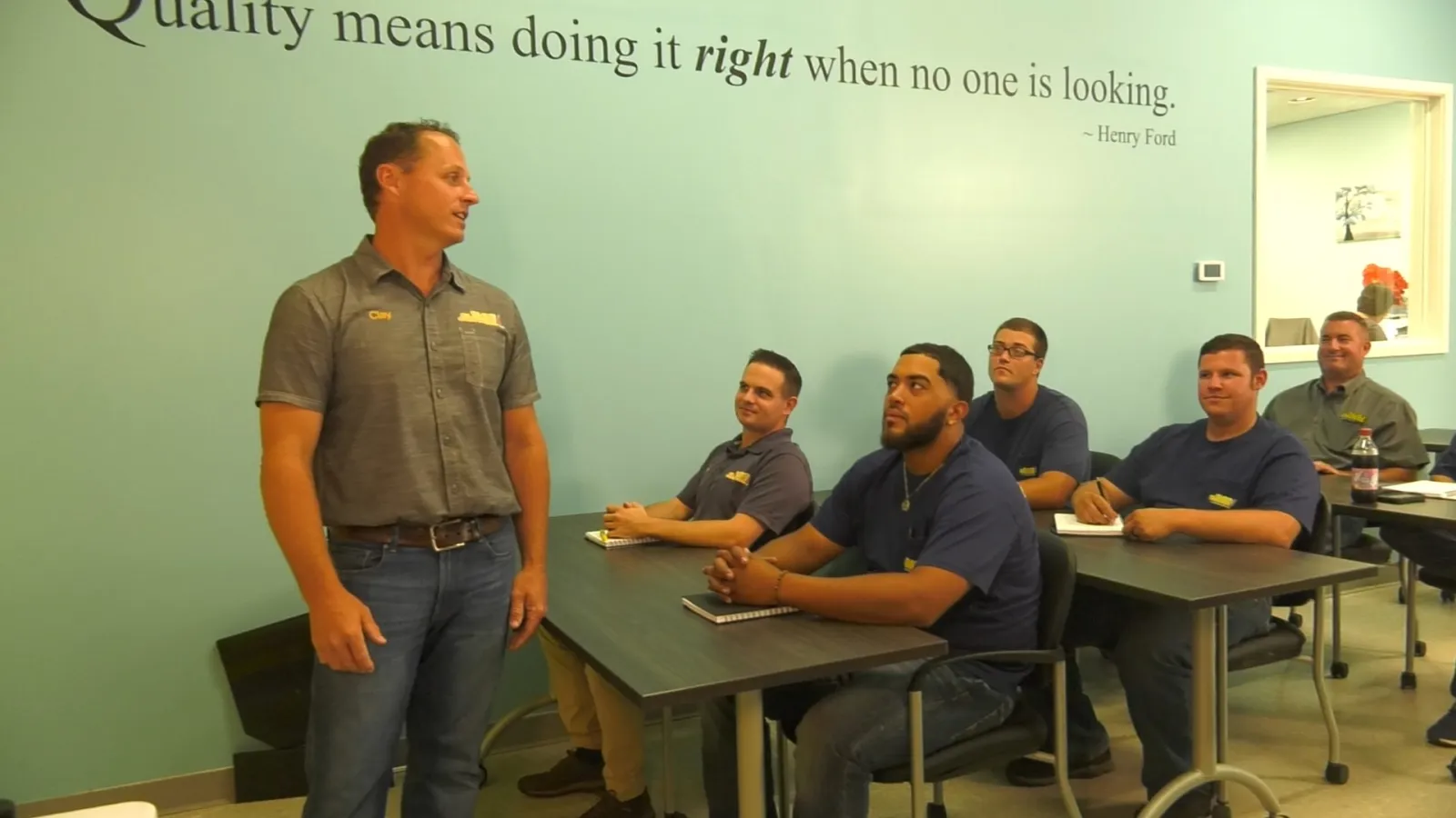 a person standing in front of a group of people sitting at tables