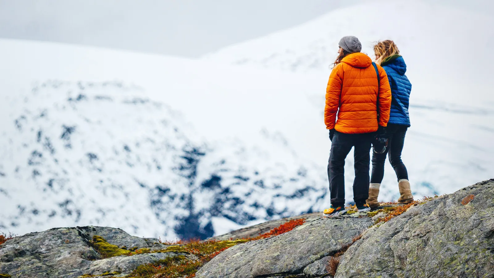 two people standing on a rock