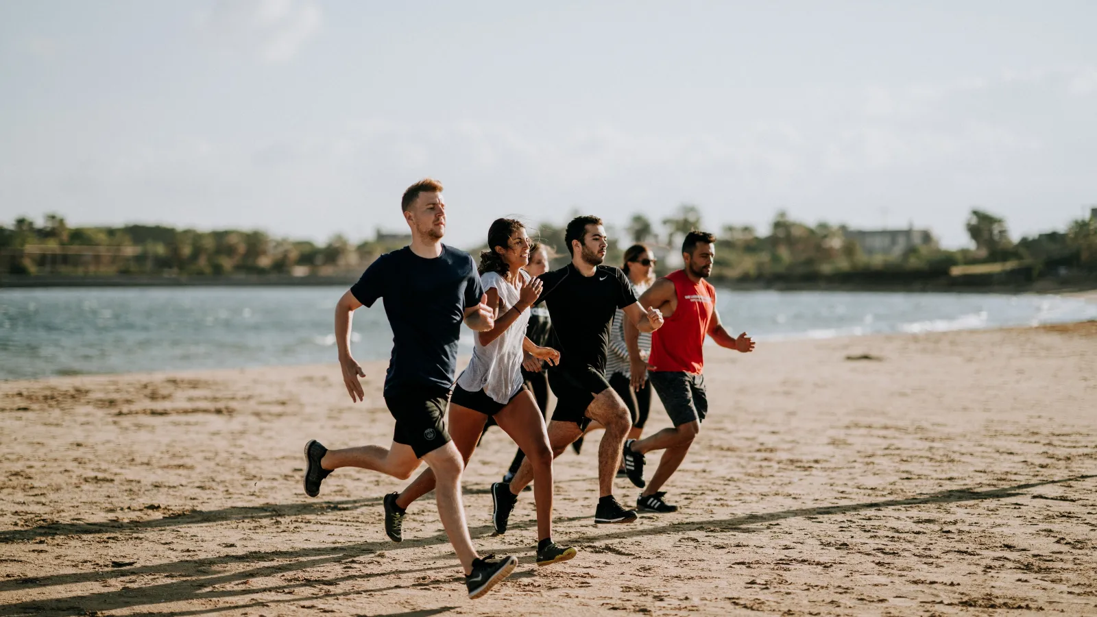 a group of people running on a beach