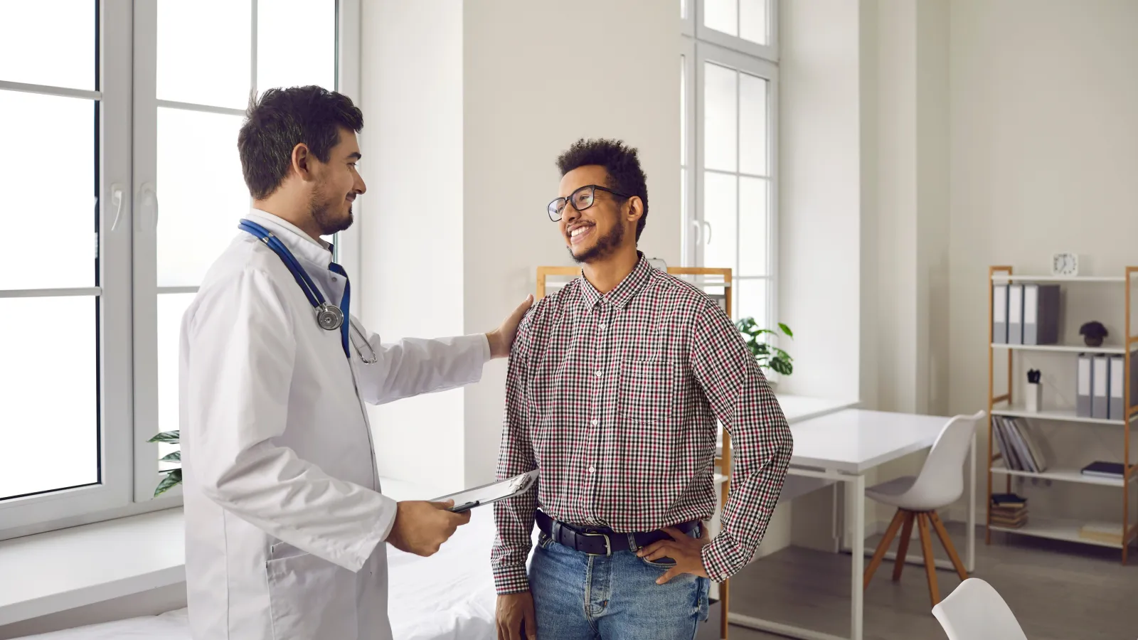 a doctor holding a clipboard next to a patient