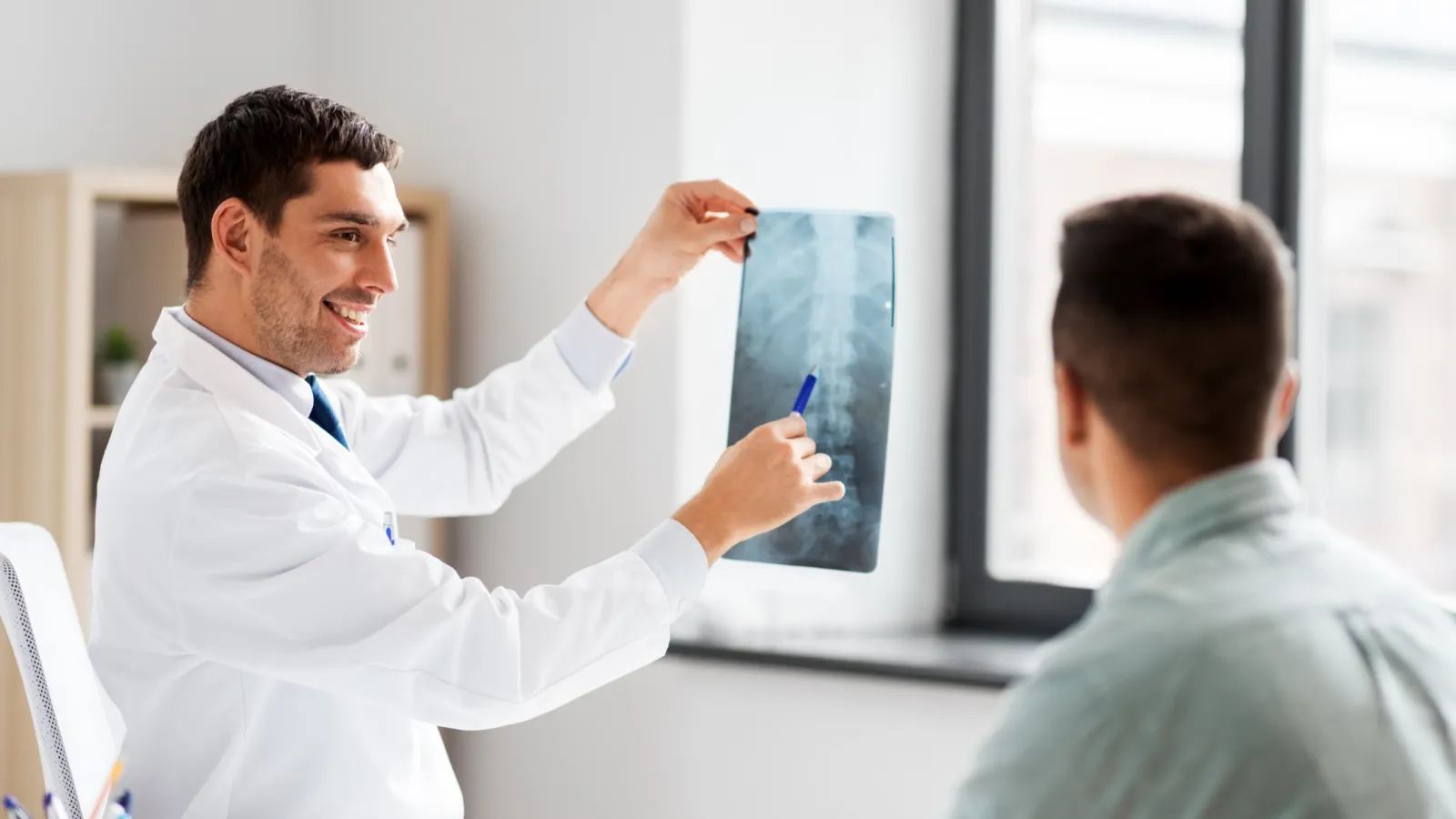a man showing a man something on an Xray
