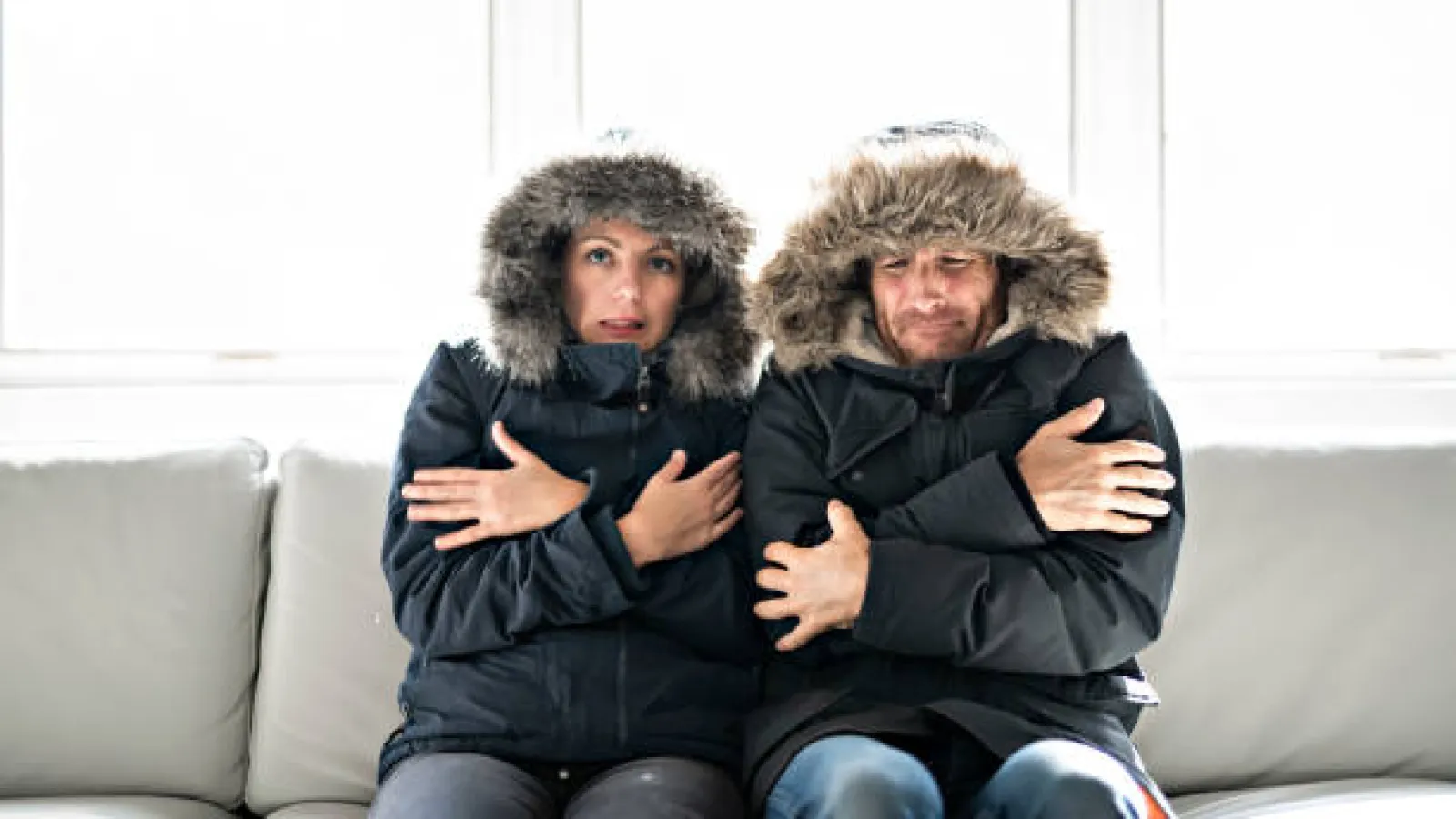 two people sitting on a couch freezing cold