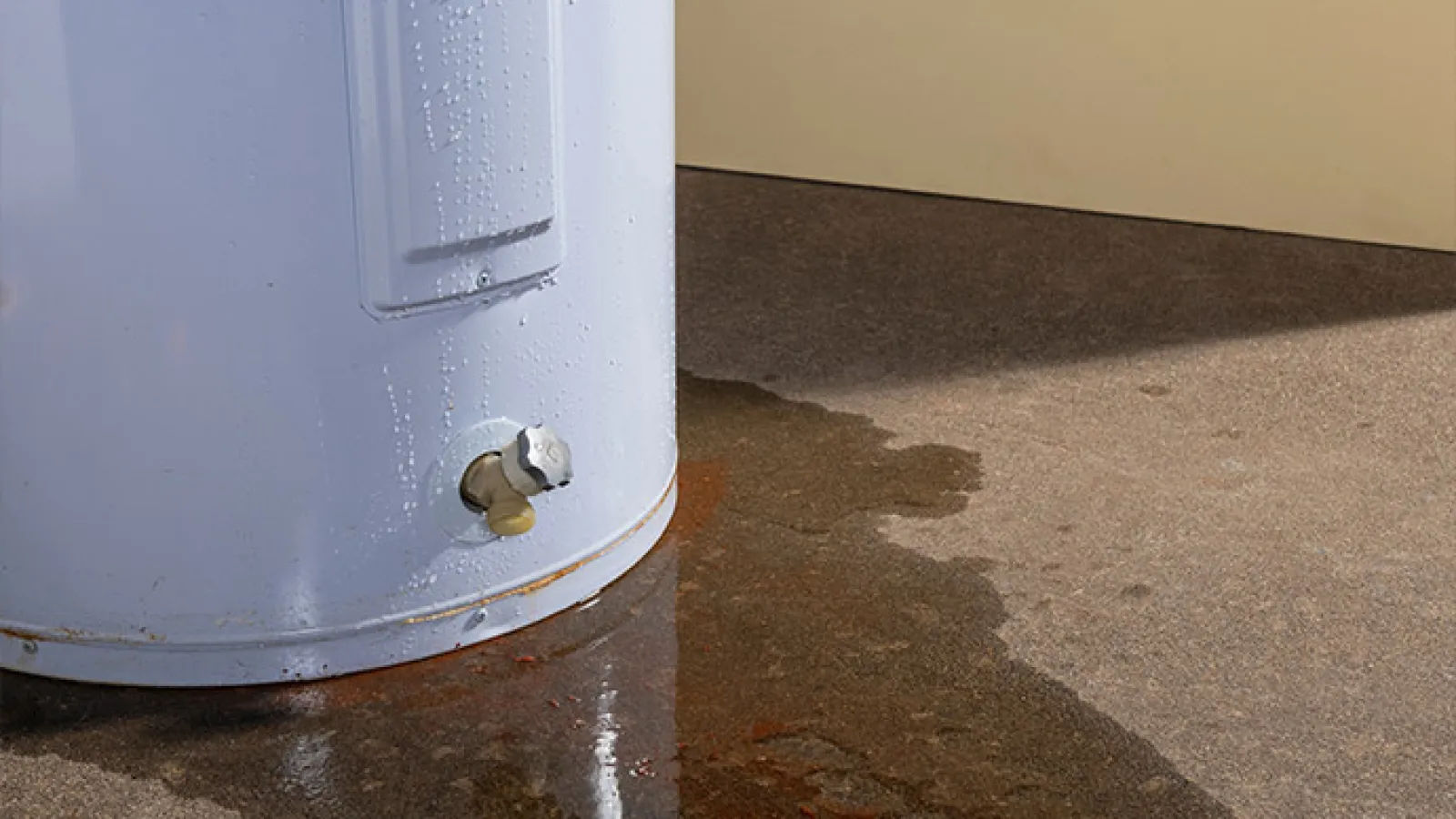 Leaking water heater in acworth, ga with water puddle on the floor indicating potential damage and maintenance need.