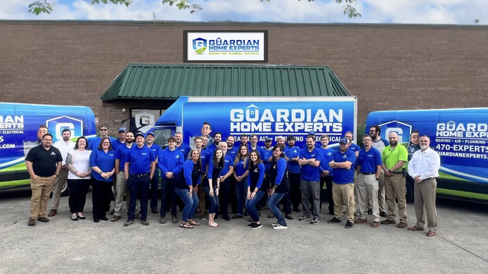 a group of people posing for a photo in front of a building