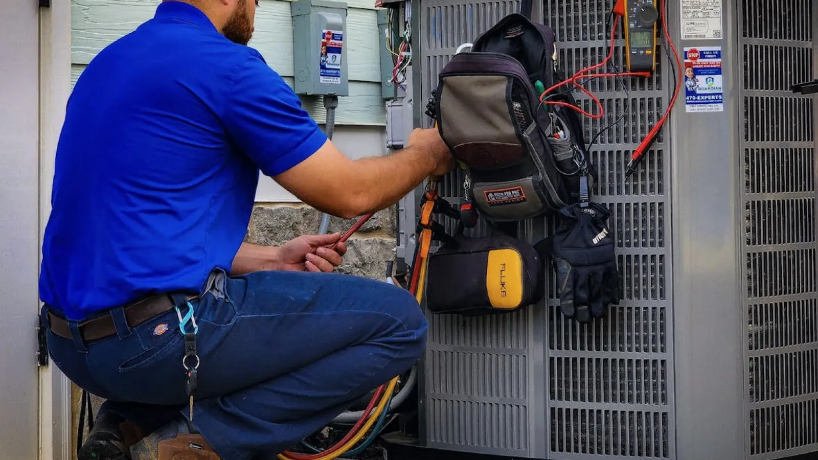 a man with a backpack and a bag on a rack next to air conditioner