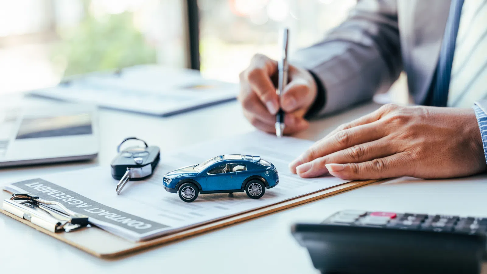 a man holding a pen and a toy car
