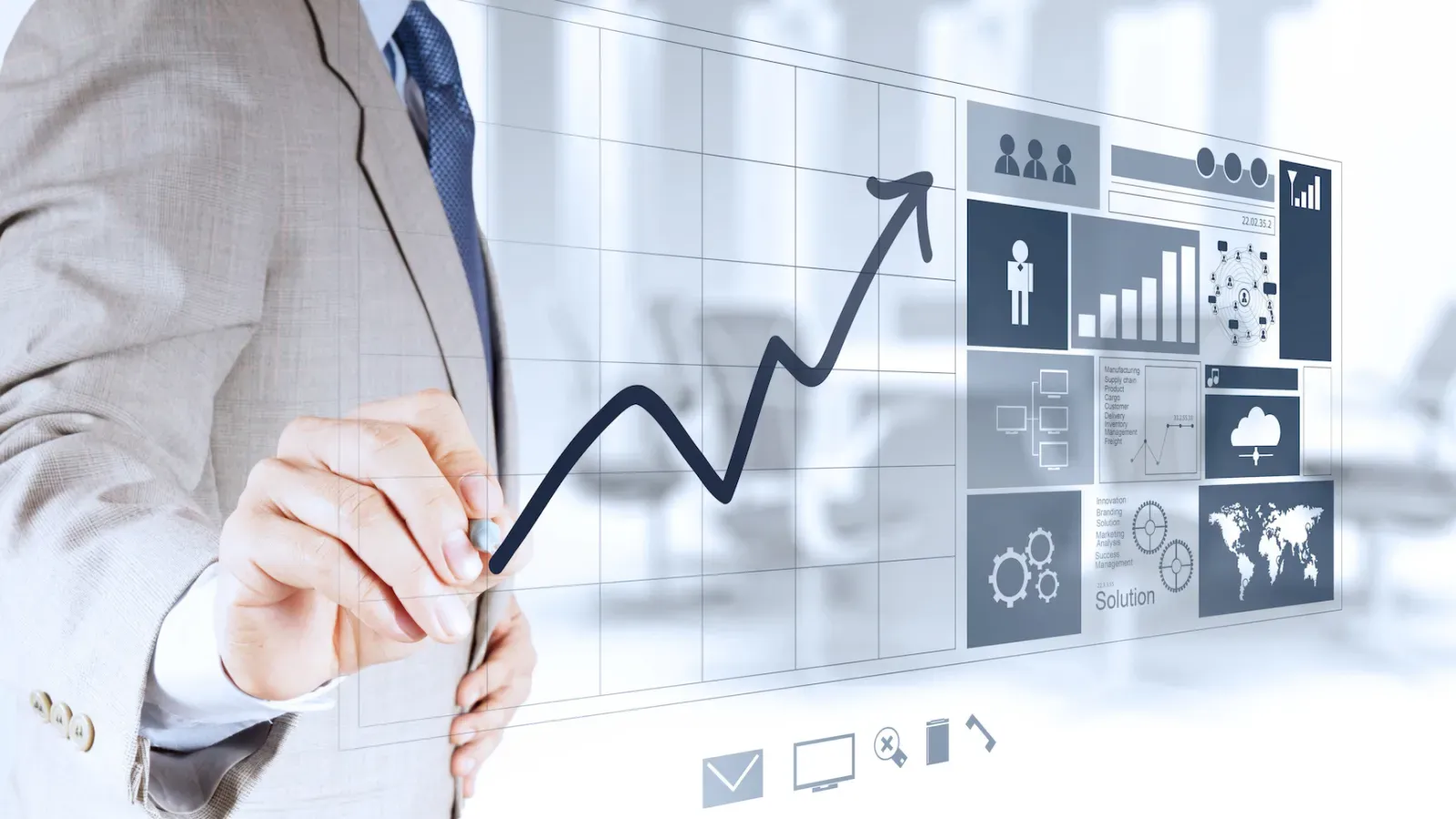 Businessman drawing an upward growth chart on a transparent digital interface with analytics and icons.