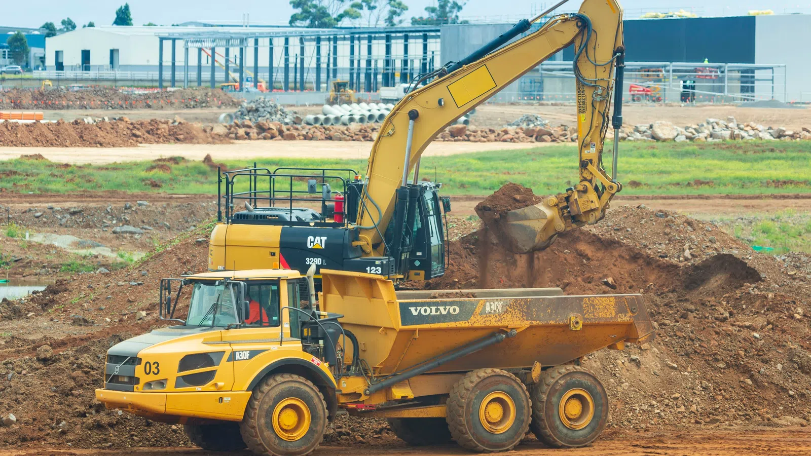a yellow bulldozer in a dirt field