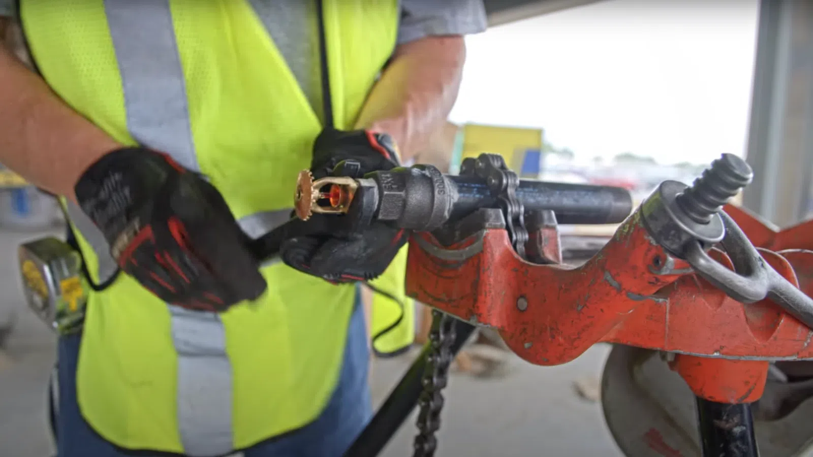 a person wearing a yellow safety vest working on a machine
