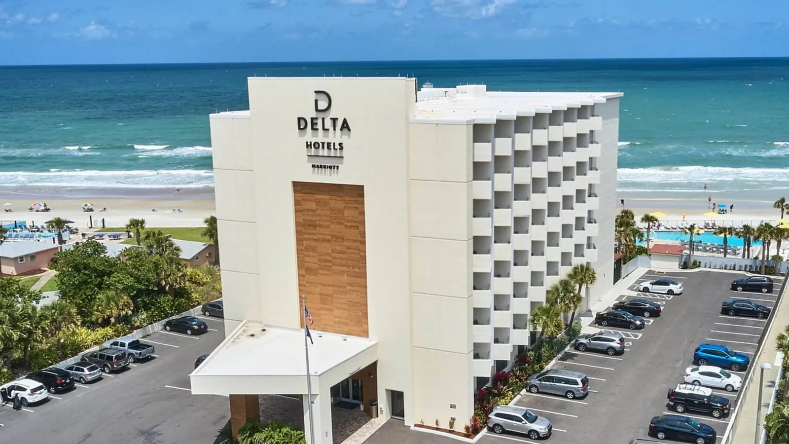 a building with cars parked in front of it by the ocean