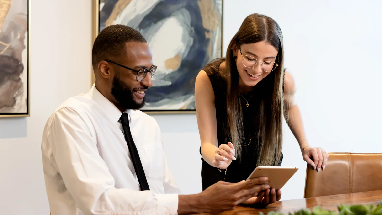 a man and a woman looking at a tablet