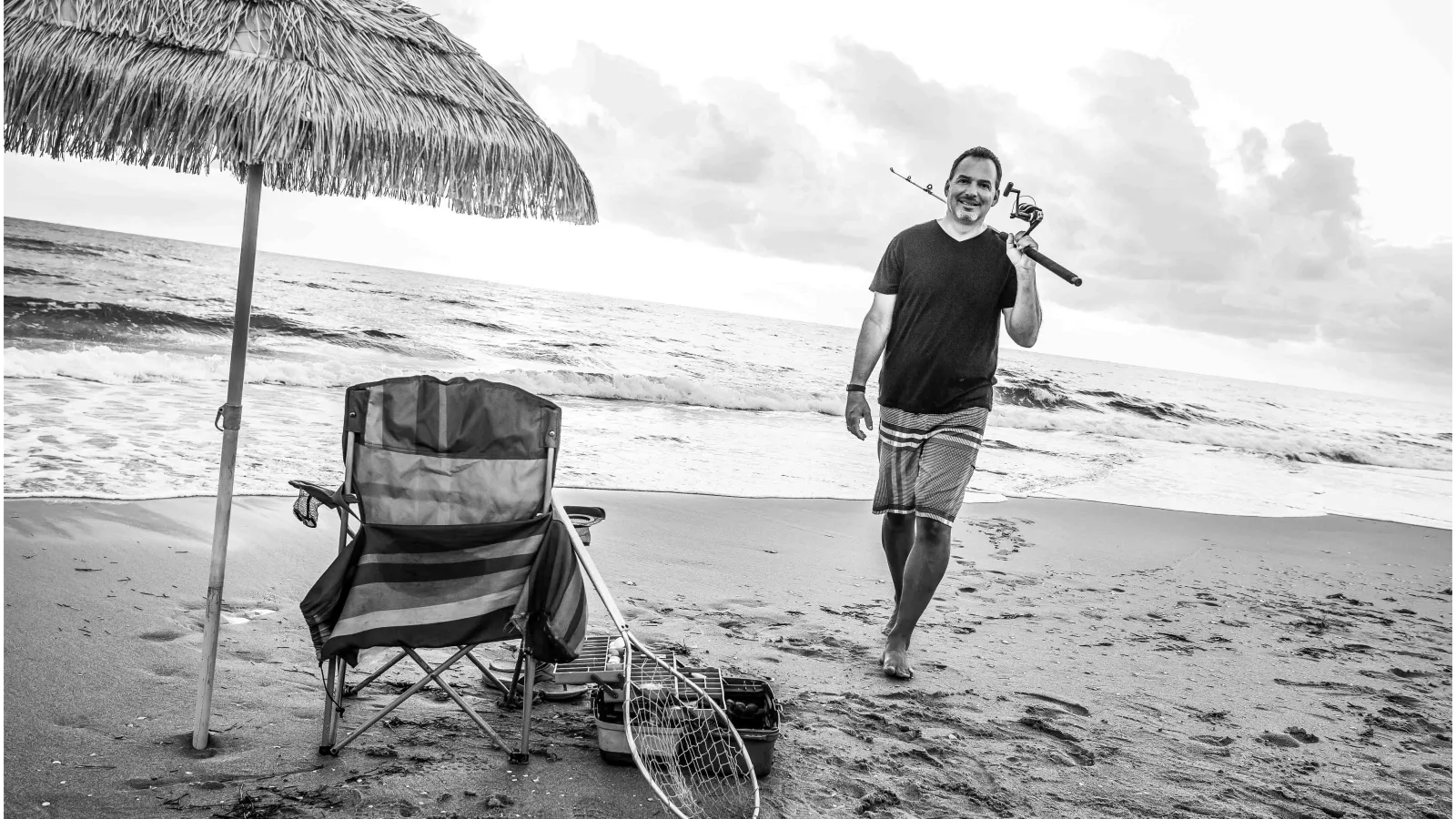 a person holding a tennis racket and a chair on a beach