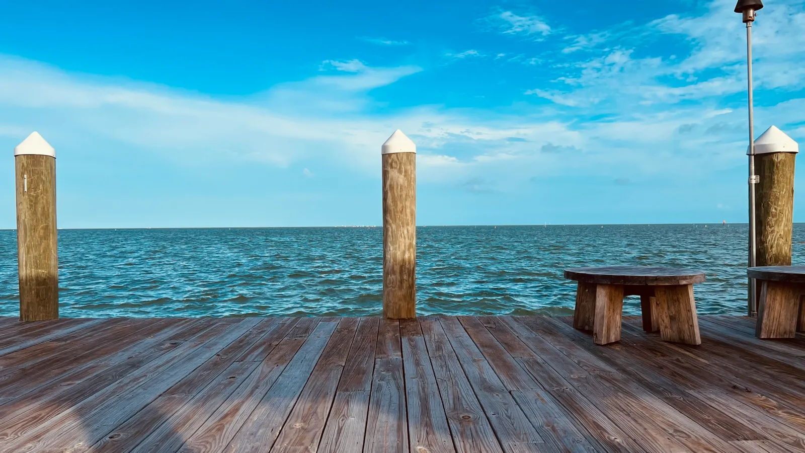 a wood dock leading out to the ocean