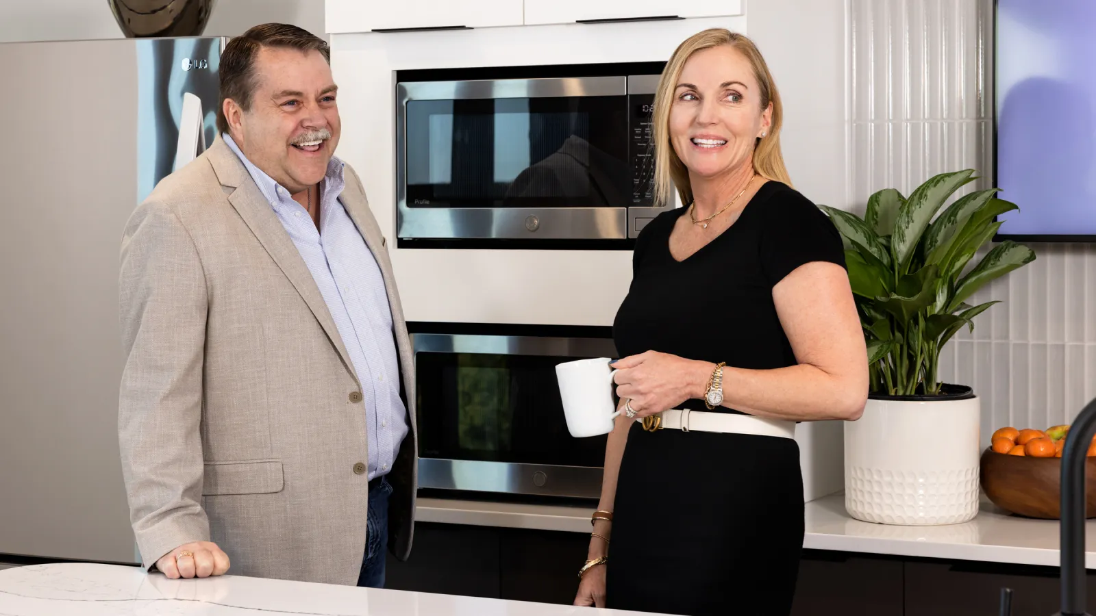 a man and a woman standing next to each other and smiling