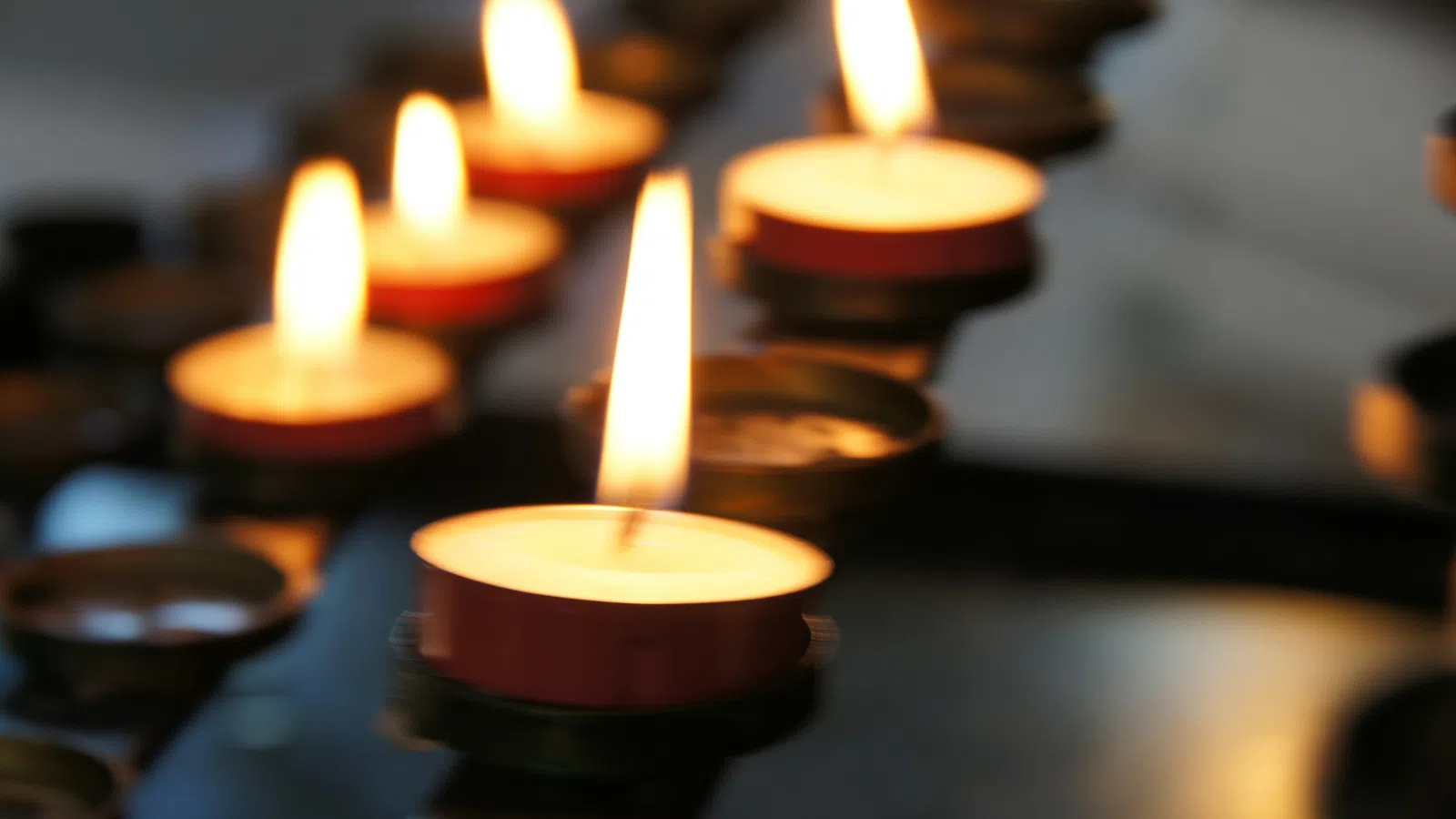 Votive candles burning softly in a decorative holder, creating a warm and serene ambiance.