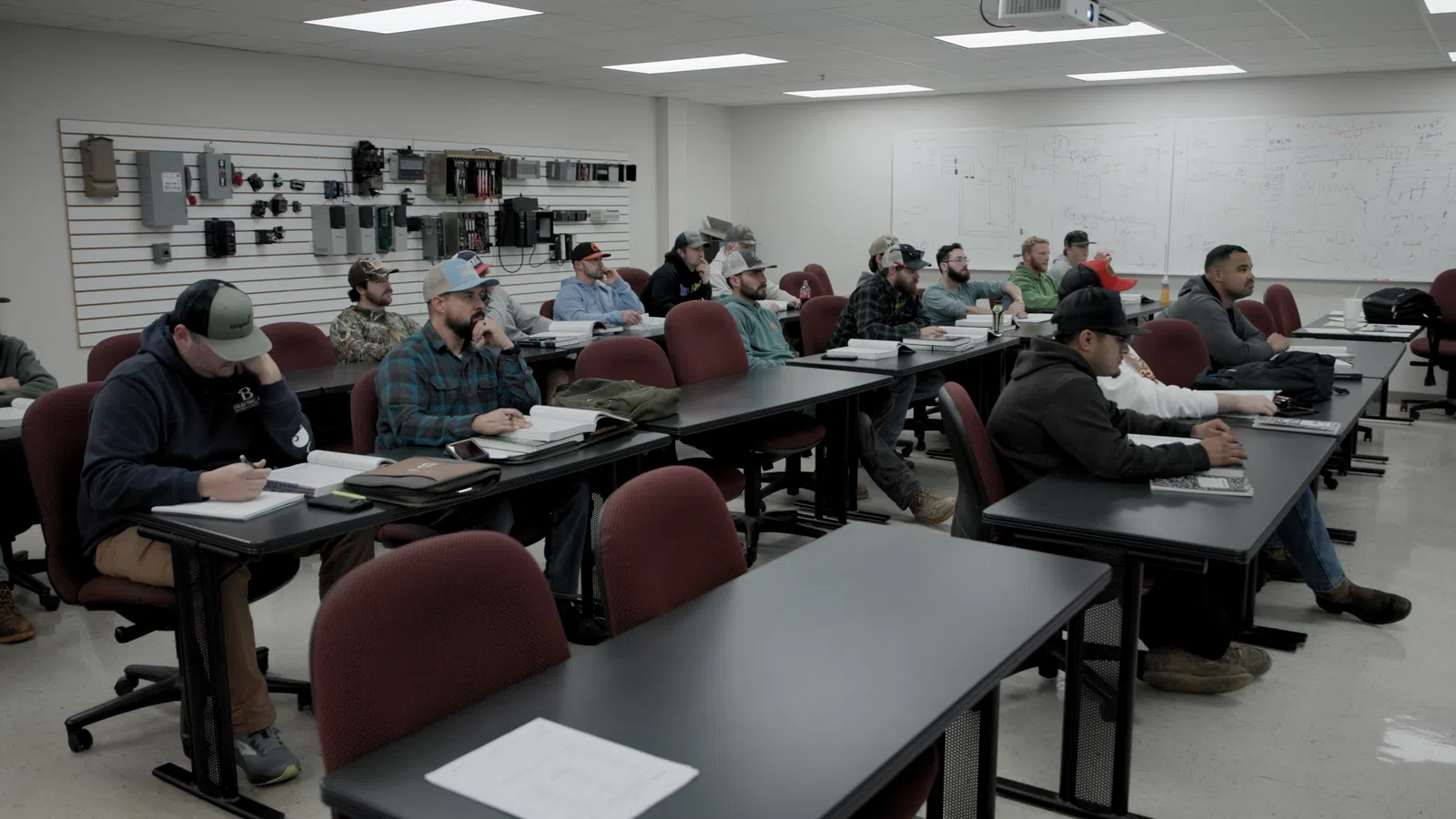 a group of people sitting at desks in a room