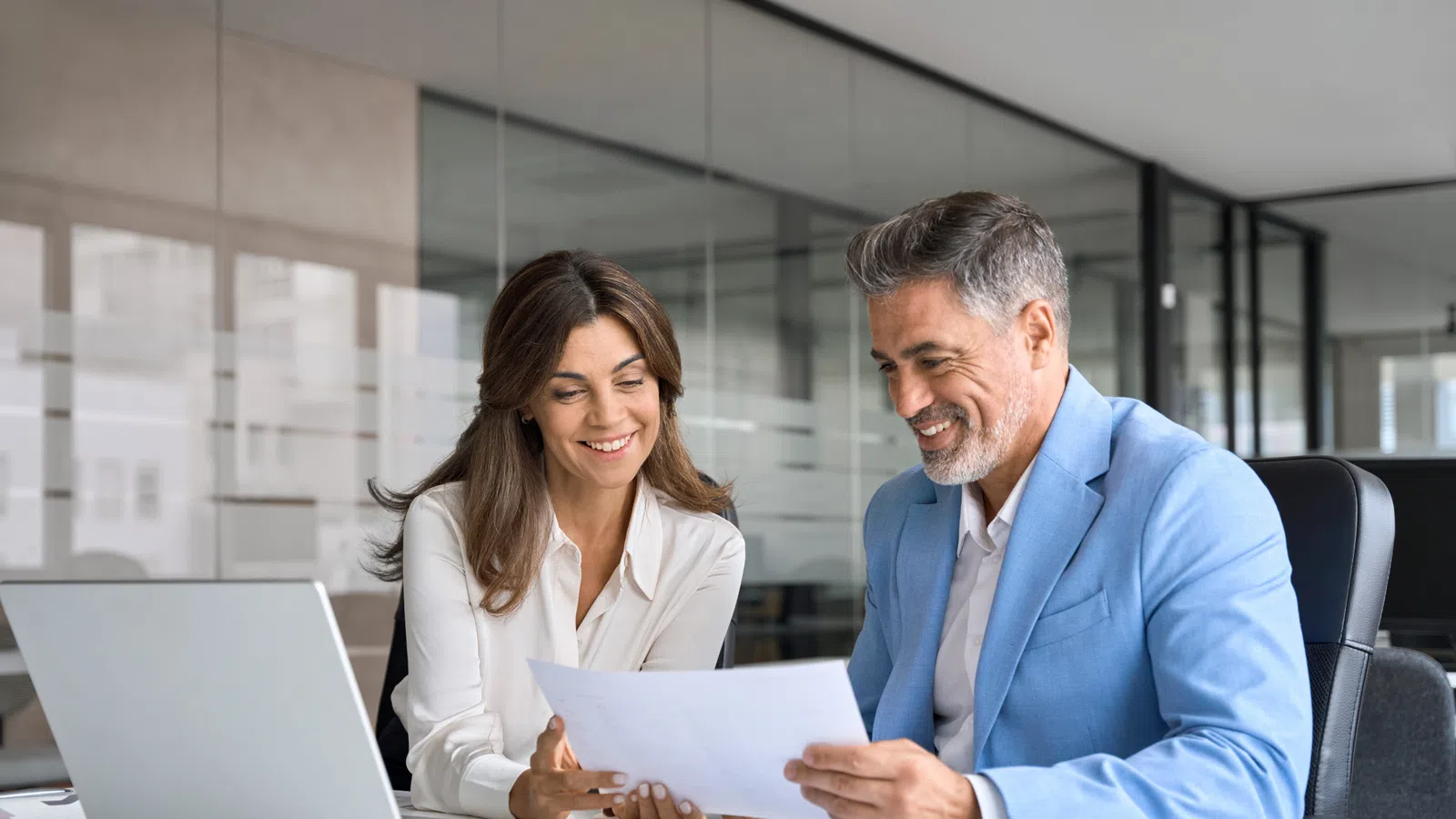 A business team reviewing documents together in a modern office setting, showcasing collaboration and professionalism.