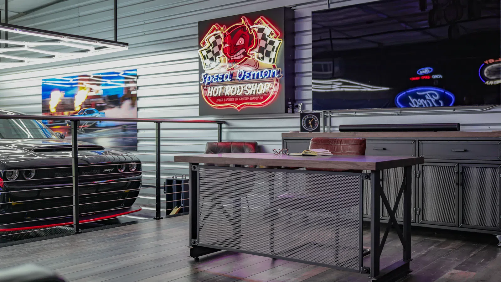 Modern garage office with a black muscle car, neon Speed Demon sign, and industrial desk under TV screens.