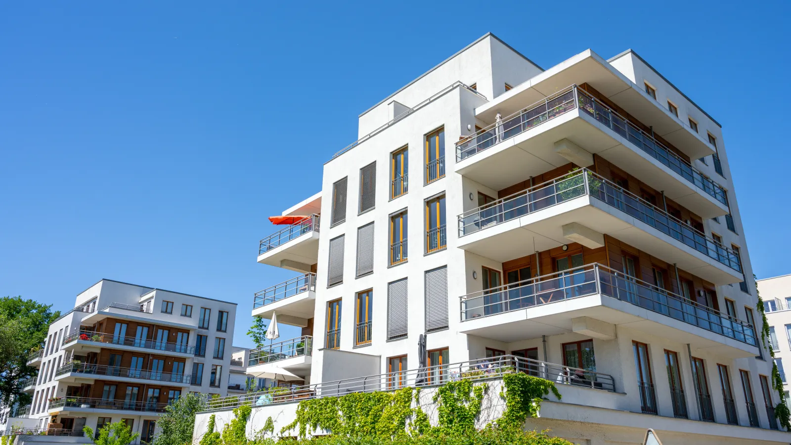 a building with balconies and trees in the front