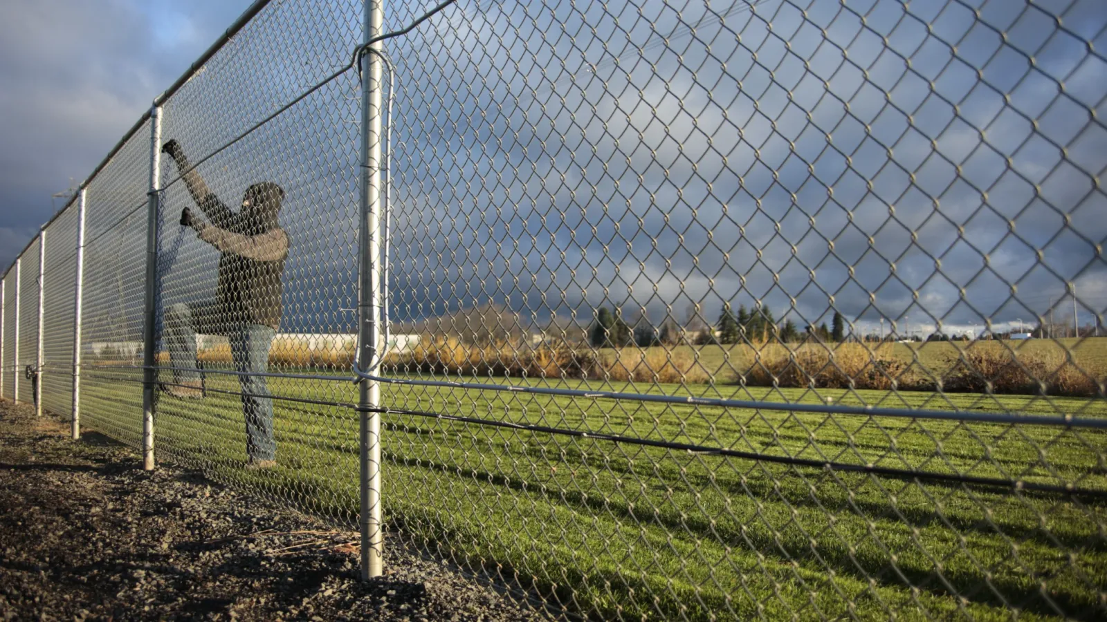 a person standing in front of a fence