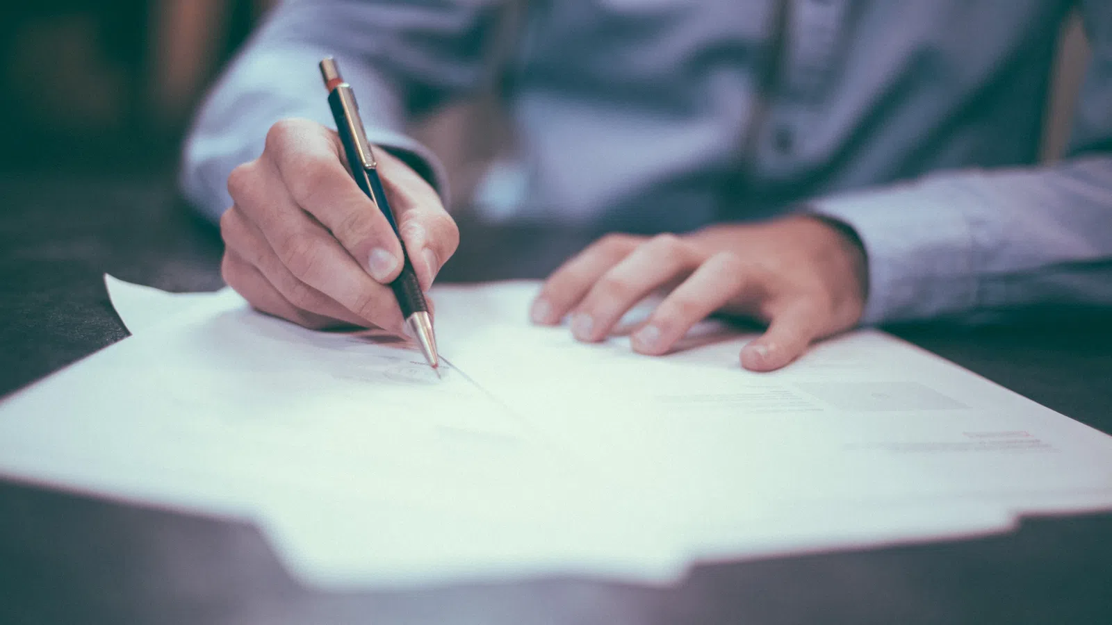 a person writing on a piece of paper