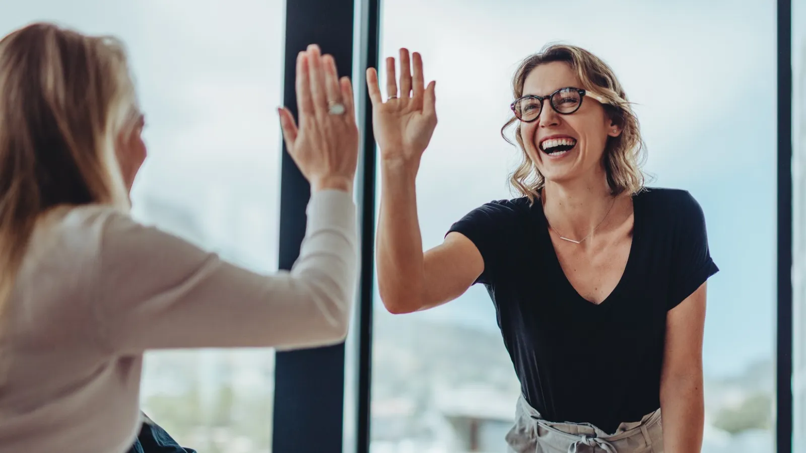 a woman sitting at a table with her hands up