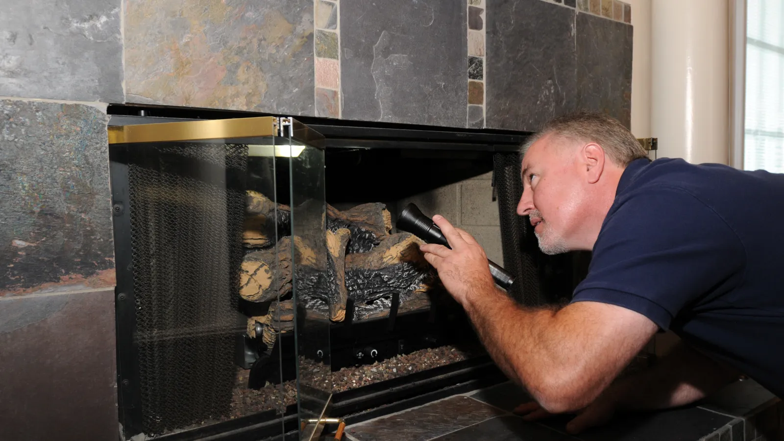 a man inspecting a fireplace