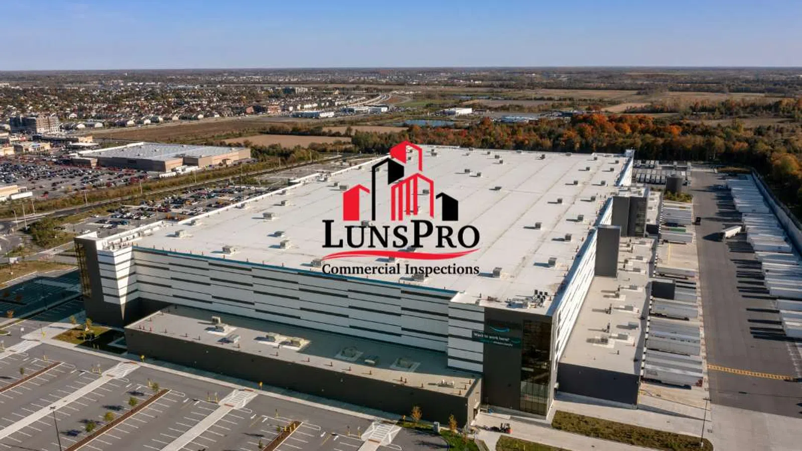 Aerial view of a large commercial warehouse with LunsPro Commercial Inspections logo overlaid on the center of the building.