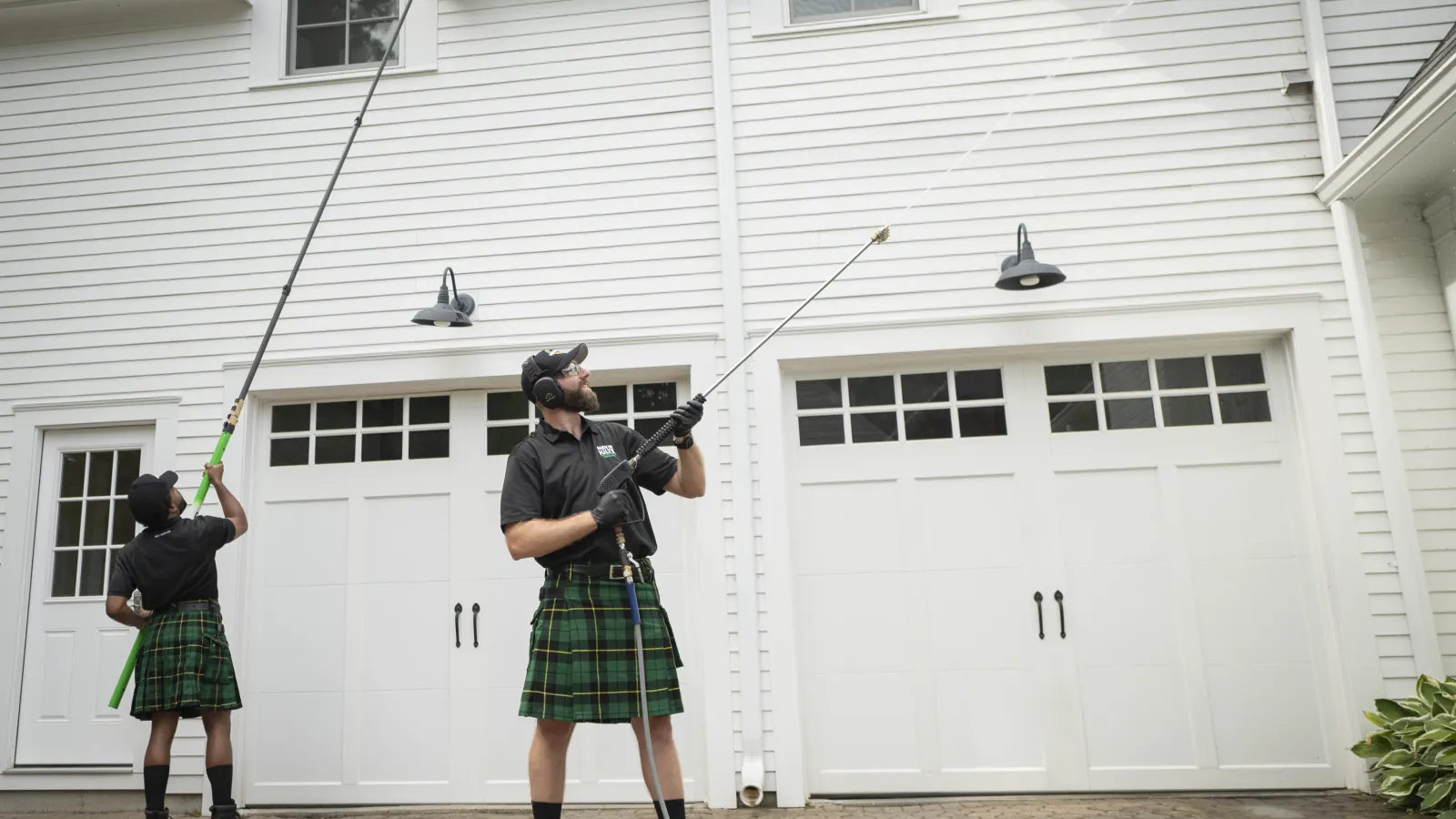 a person in a kilt holding a gun in front of a white building