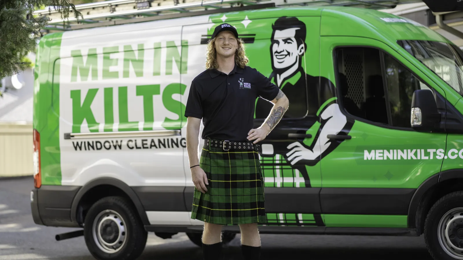 a person in a kilt standing in front of a green van