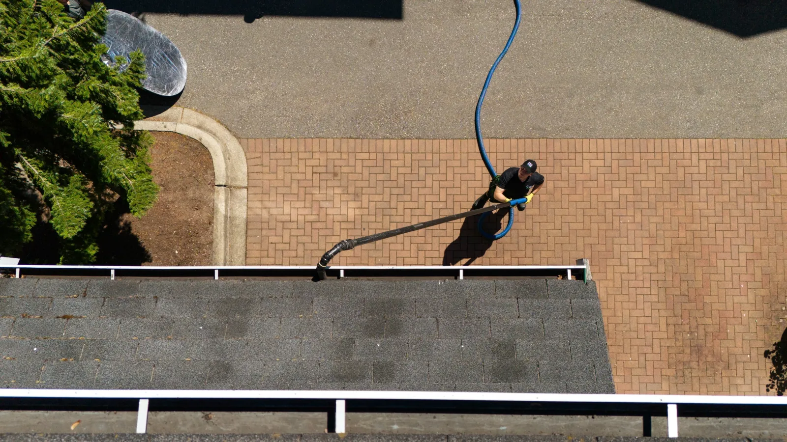 a man cleaning gutters with a gutter vacuum