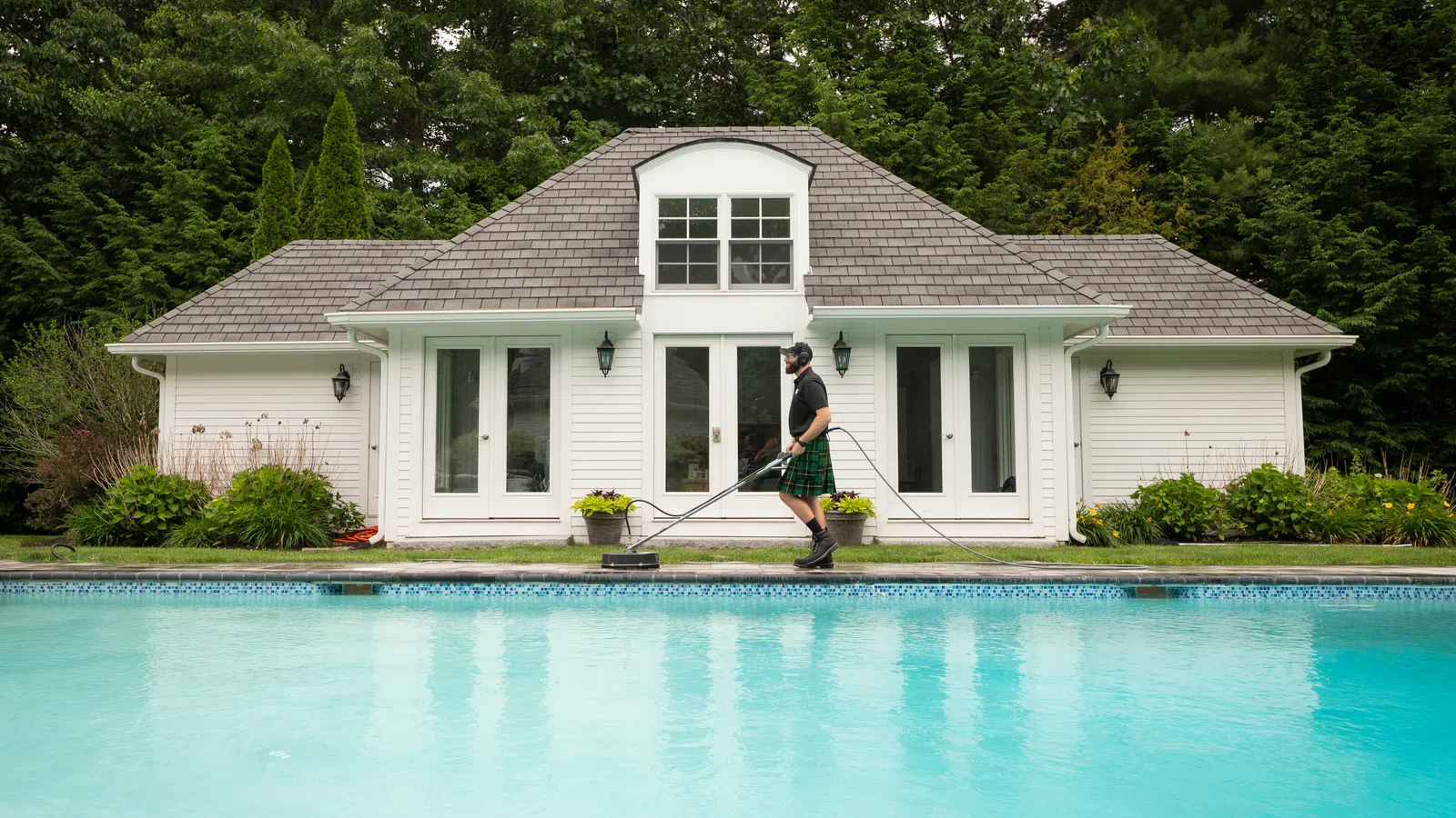 a person holding a surfboard next to a swimming pool