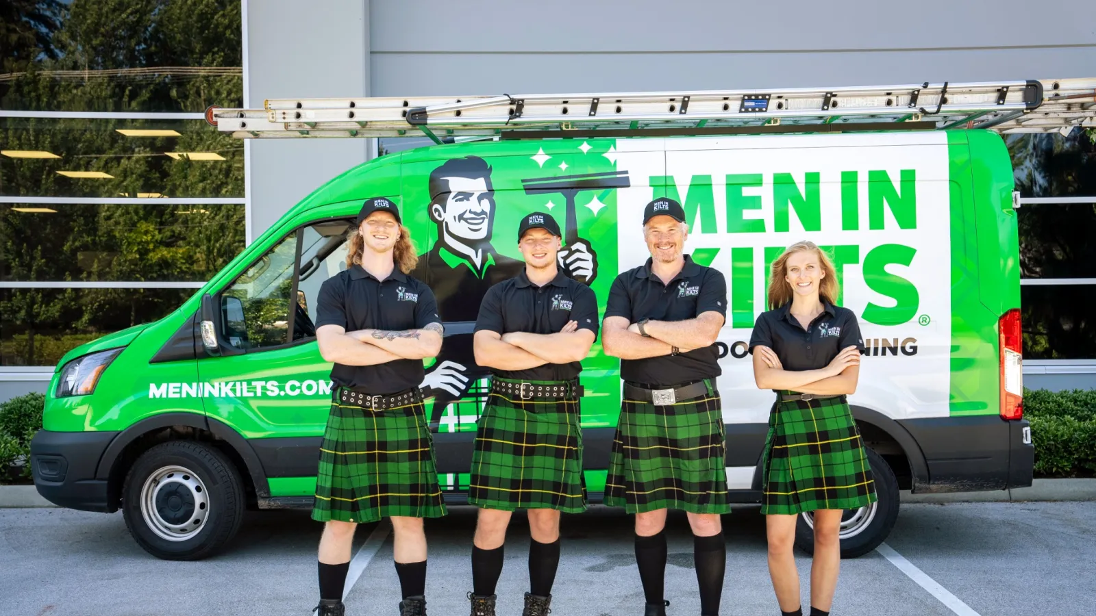 a group of people in kilts standing in front of a green van