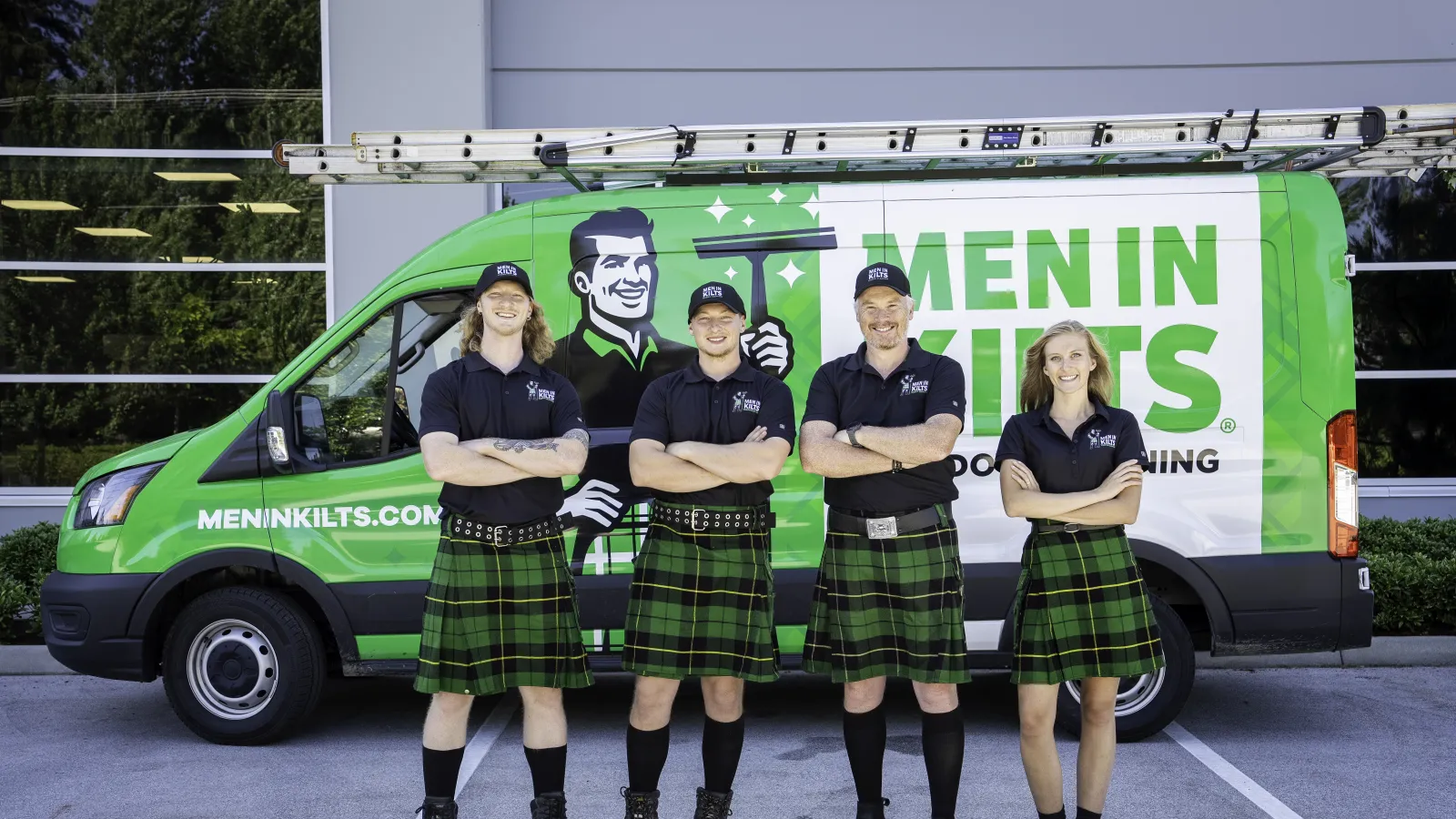 a group of people in kilts standing in front of a green van