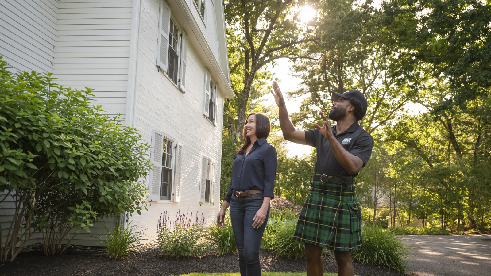 a man and woman posing for a picture in front of a house