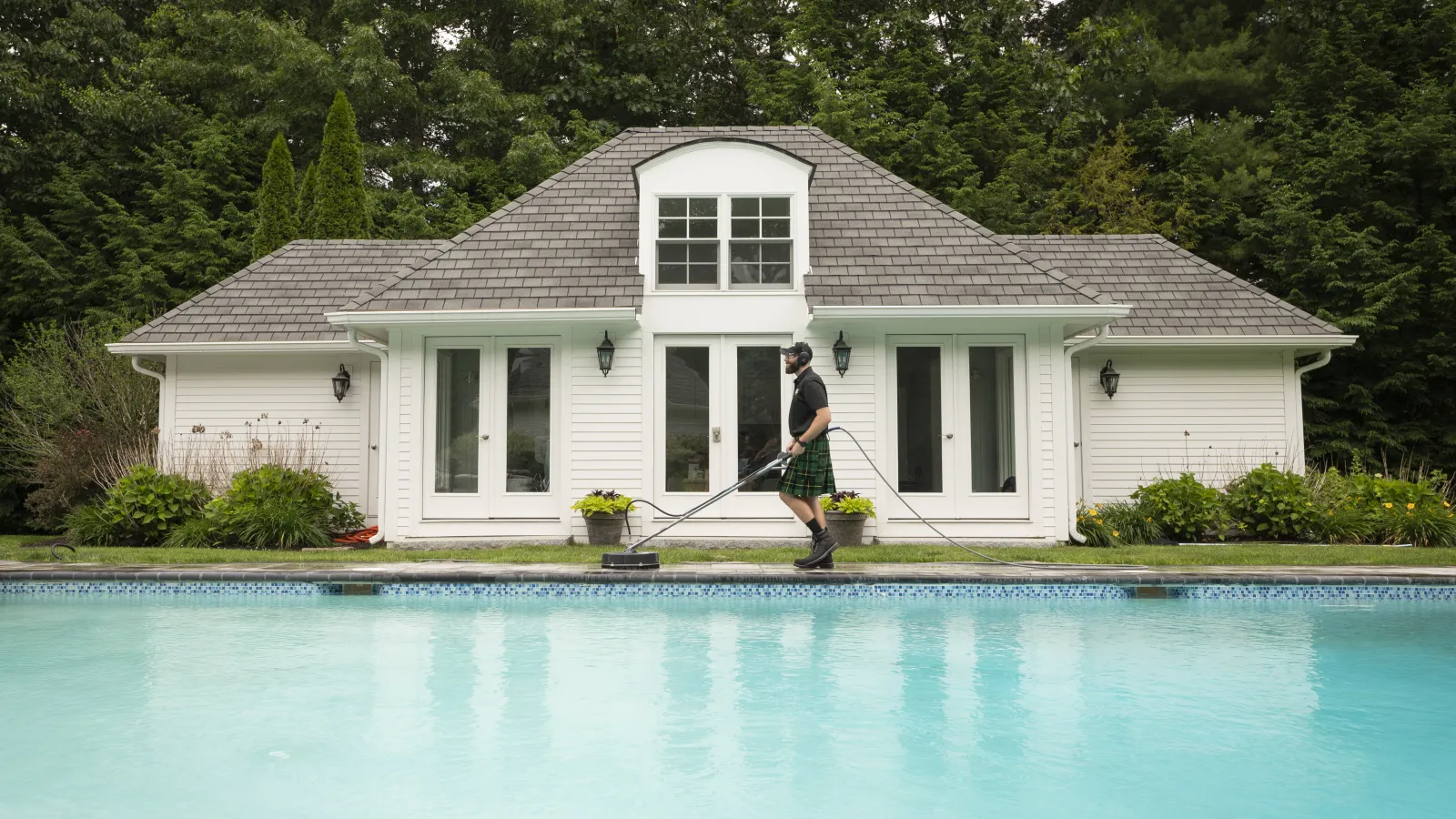 a person holding a surfboard next to a swimming pool