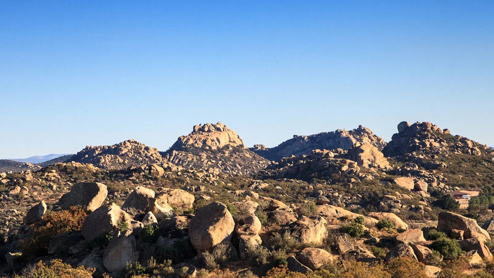 a rocky landscape with a house in the distance