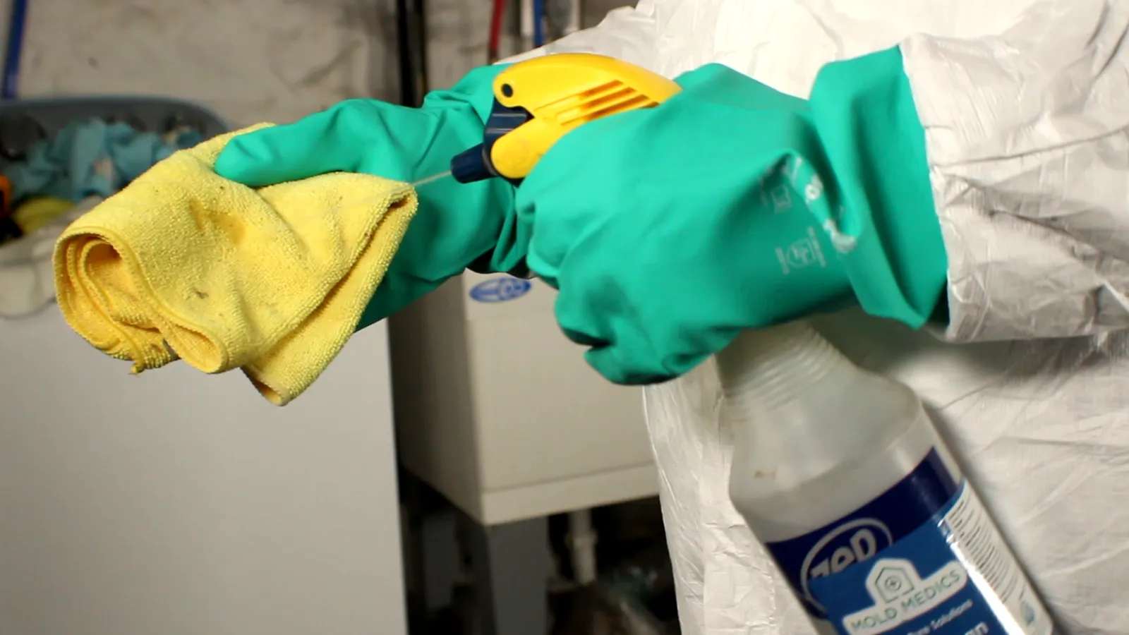 Disinfectant sprayed on yellow microfiber cloth for surface cleaning to remove remaining mold spores.
