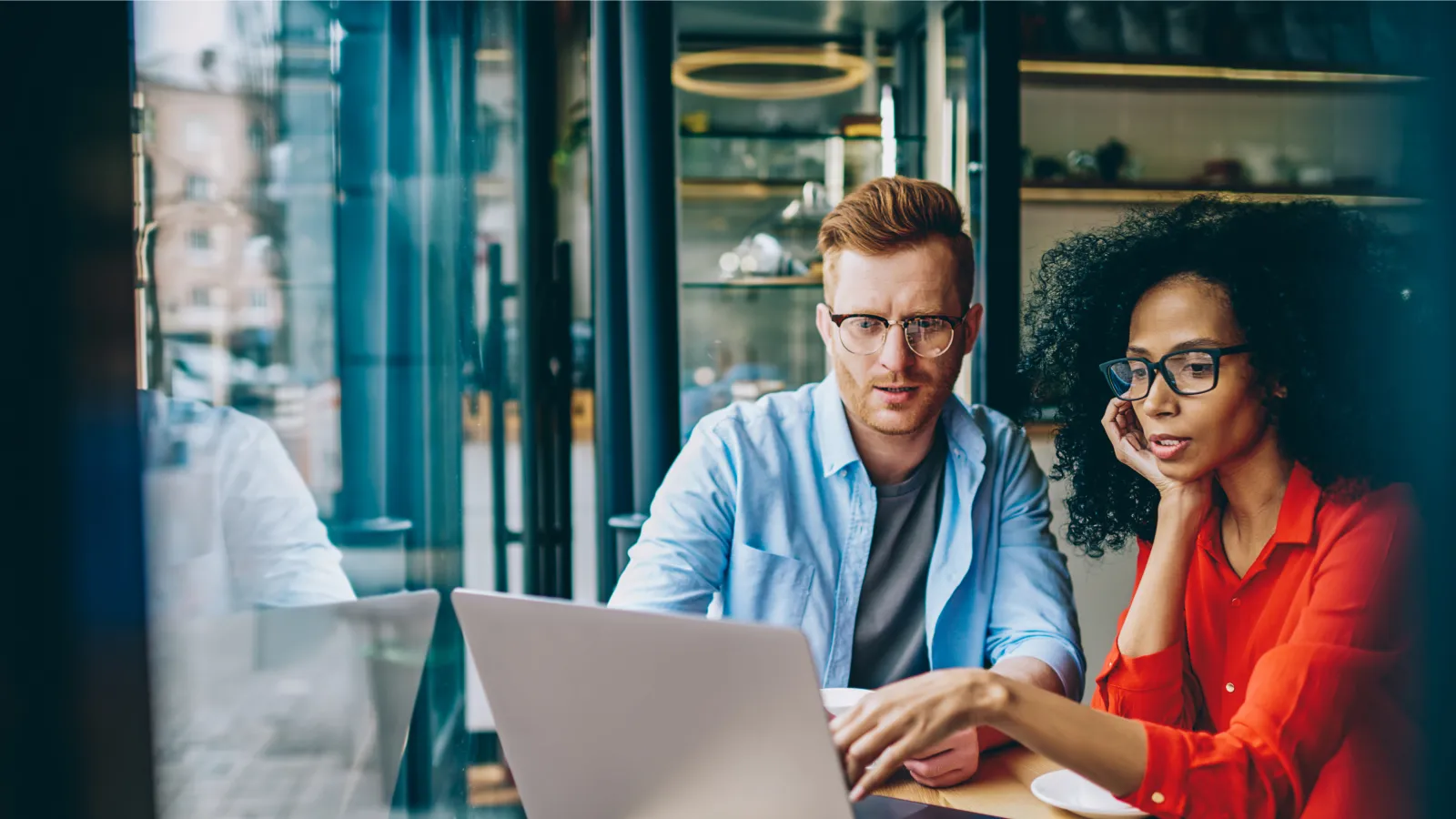 a man and a woman looking at a laptop