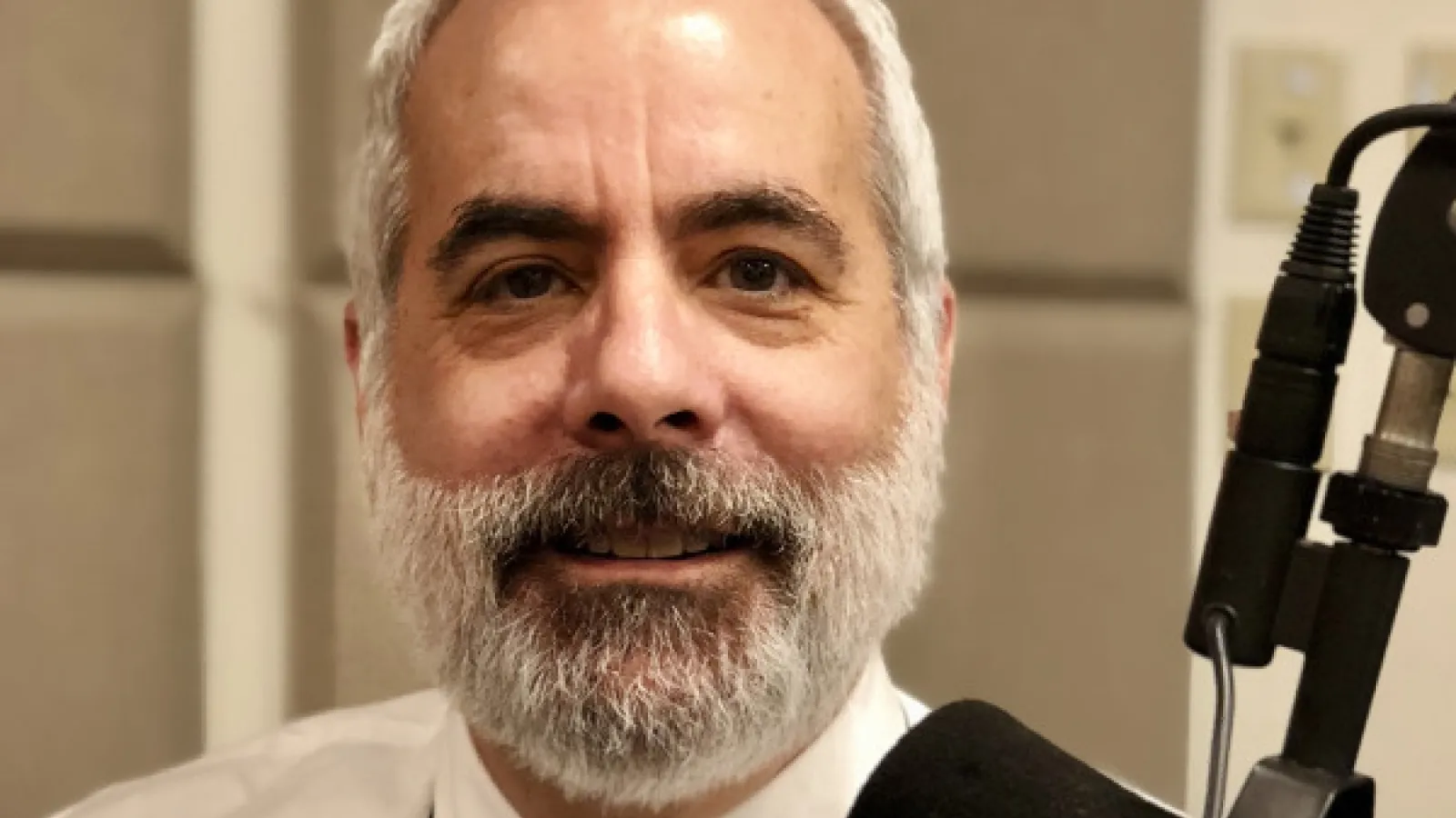 a man with a beard and a tie holding a gun