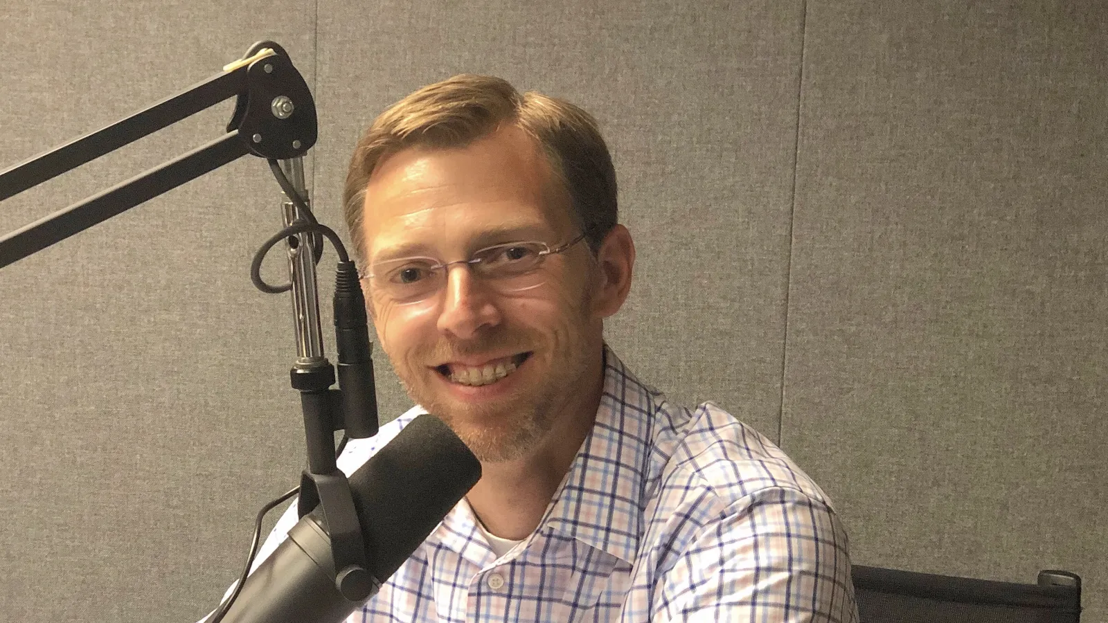 a person smiling with a microphone