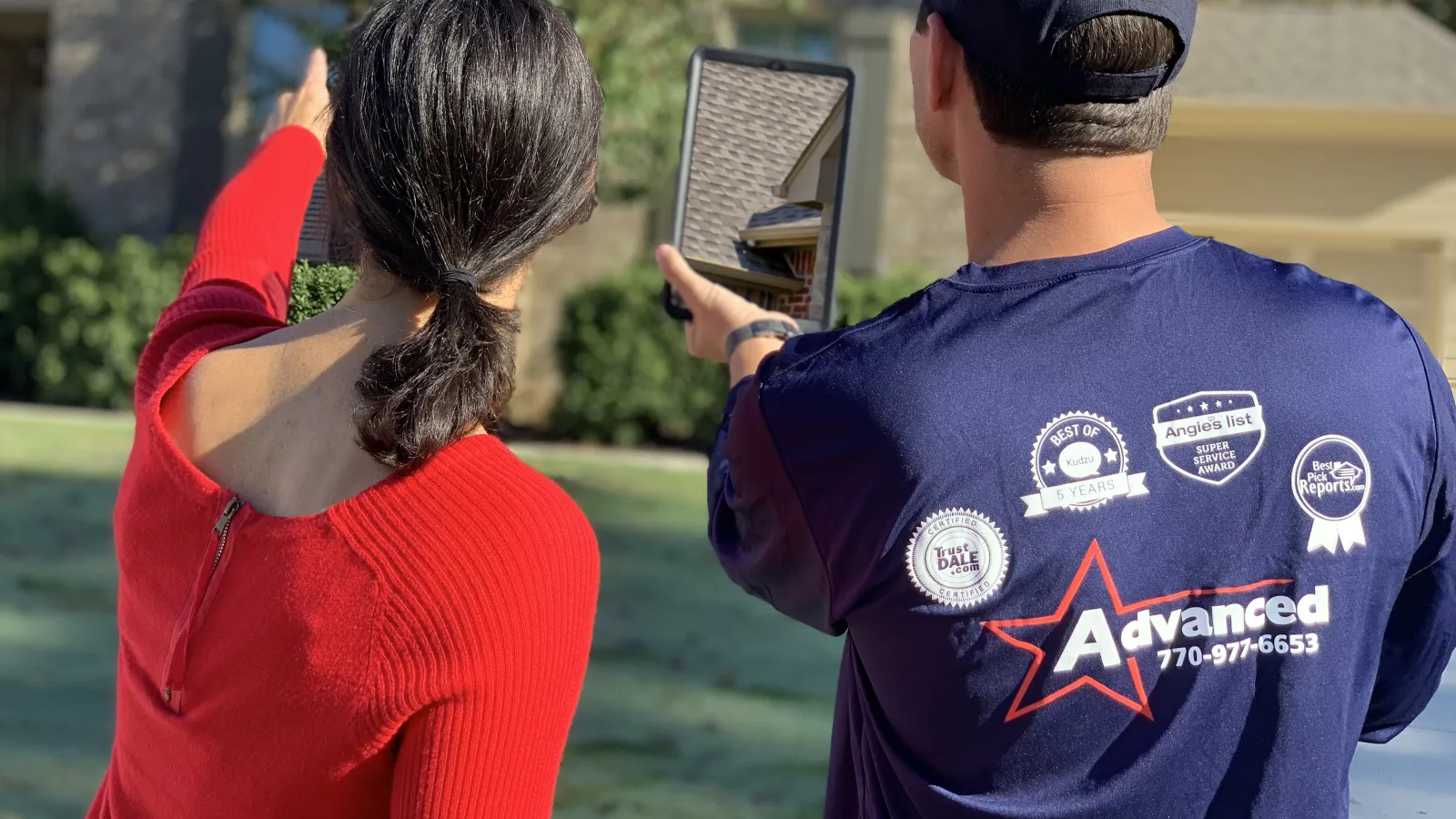 a woman taking a picture of a man holding a camera