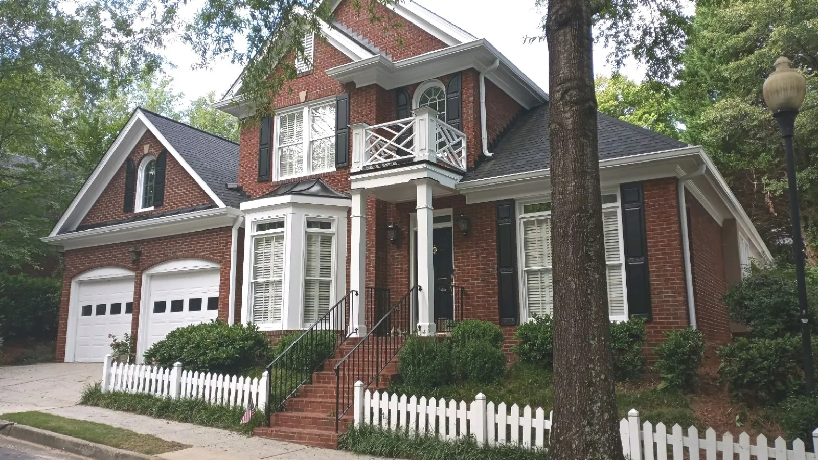 a red house with a white picket fence and a white picket fence