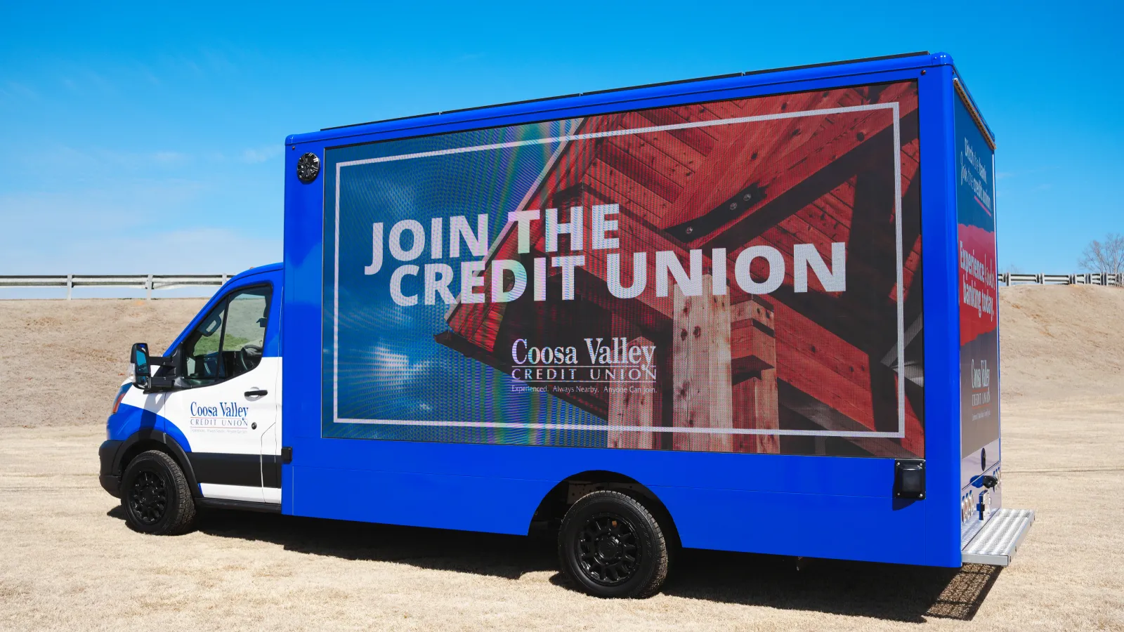 Blue Coosa Valley Credit Union truck with large digital screen displaying Join the Credit Union message outdoors.