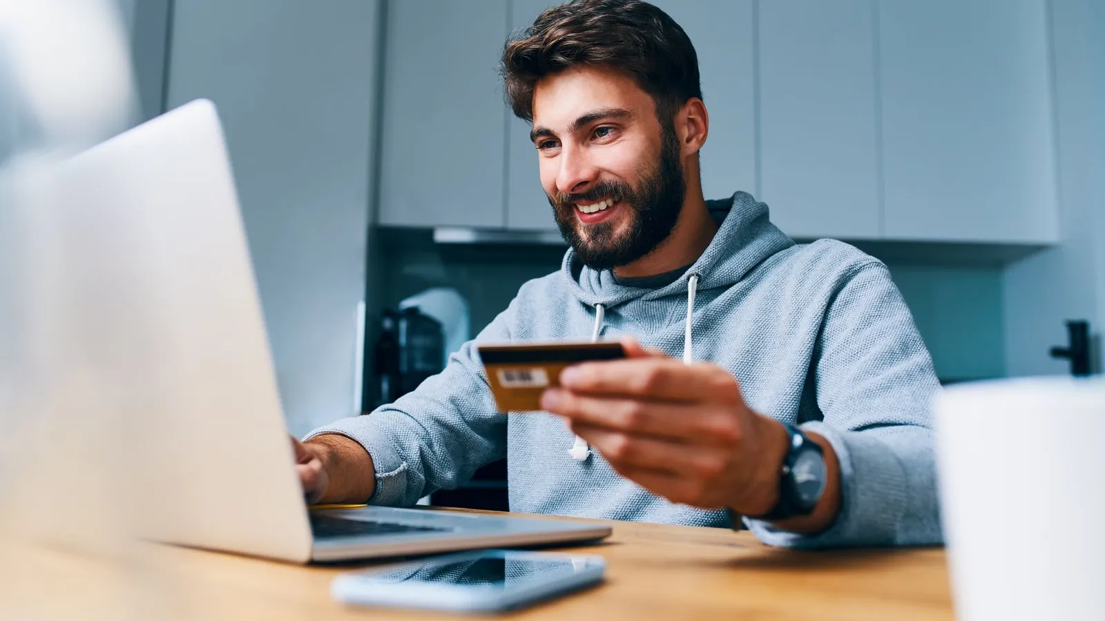 a man sitting at a desk with a laptop and a phone