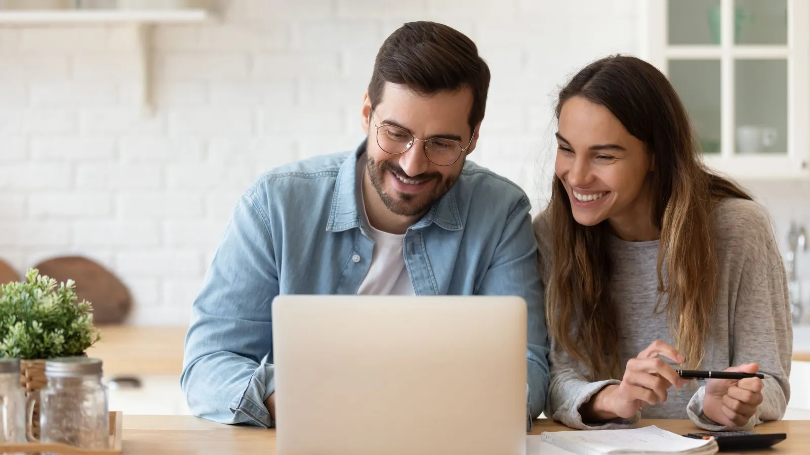 a man and a woman looking at a laptop