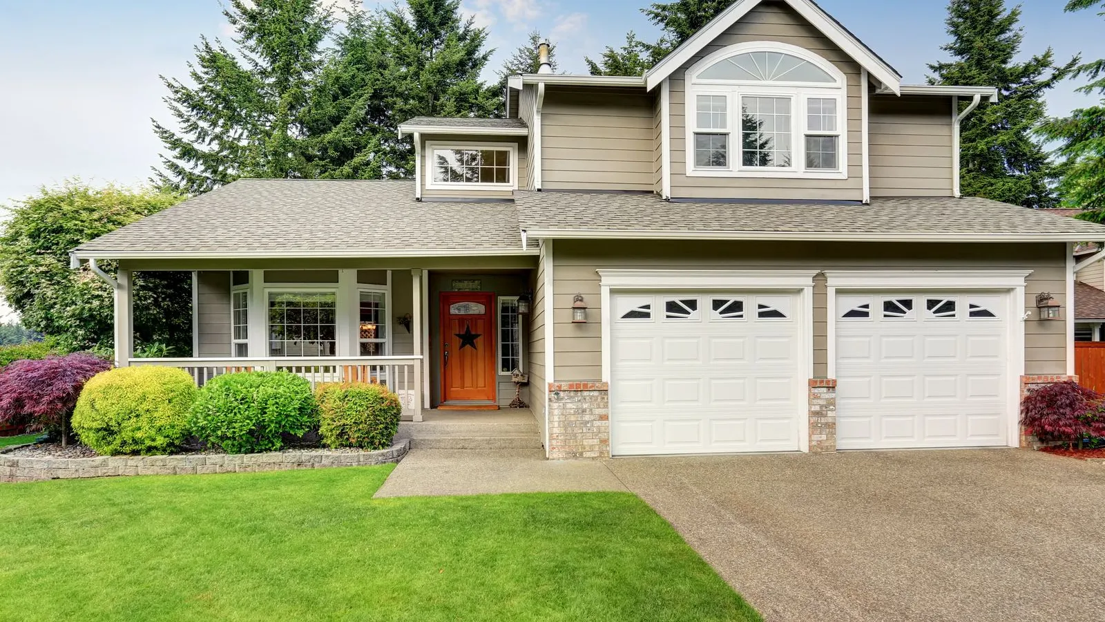a house with a garage and a lawn in front of it